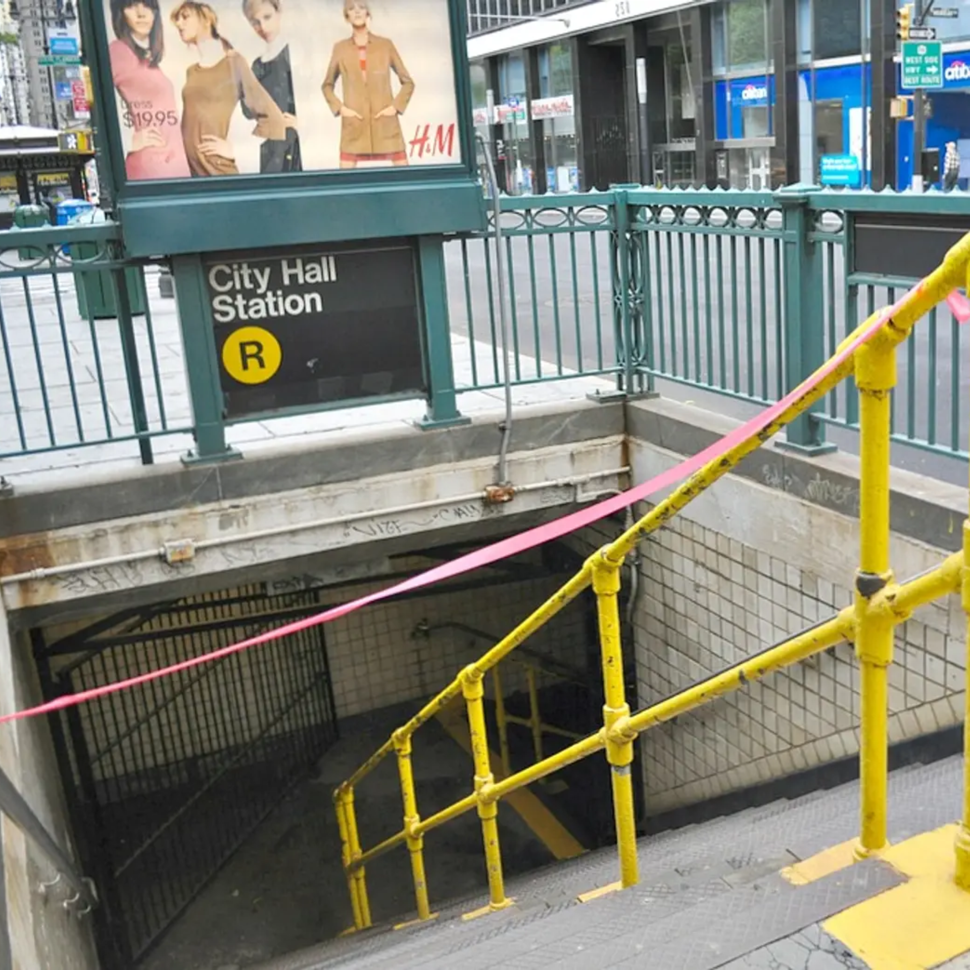 Closed City Hall Station entrance with R line sign and H&M ad above