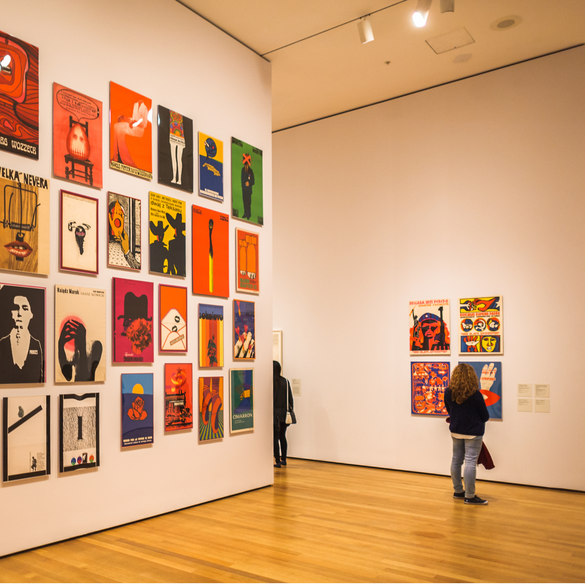 Art gallery interior with colorful modern posters displayed on white walls at a contemporary museum exhibition