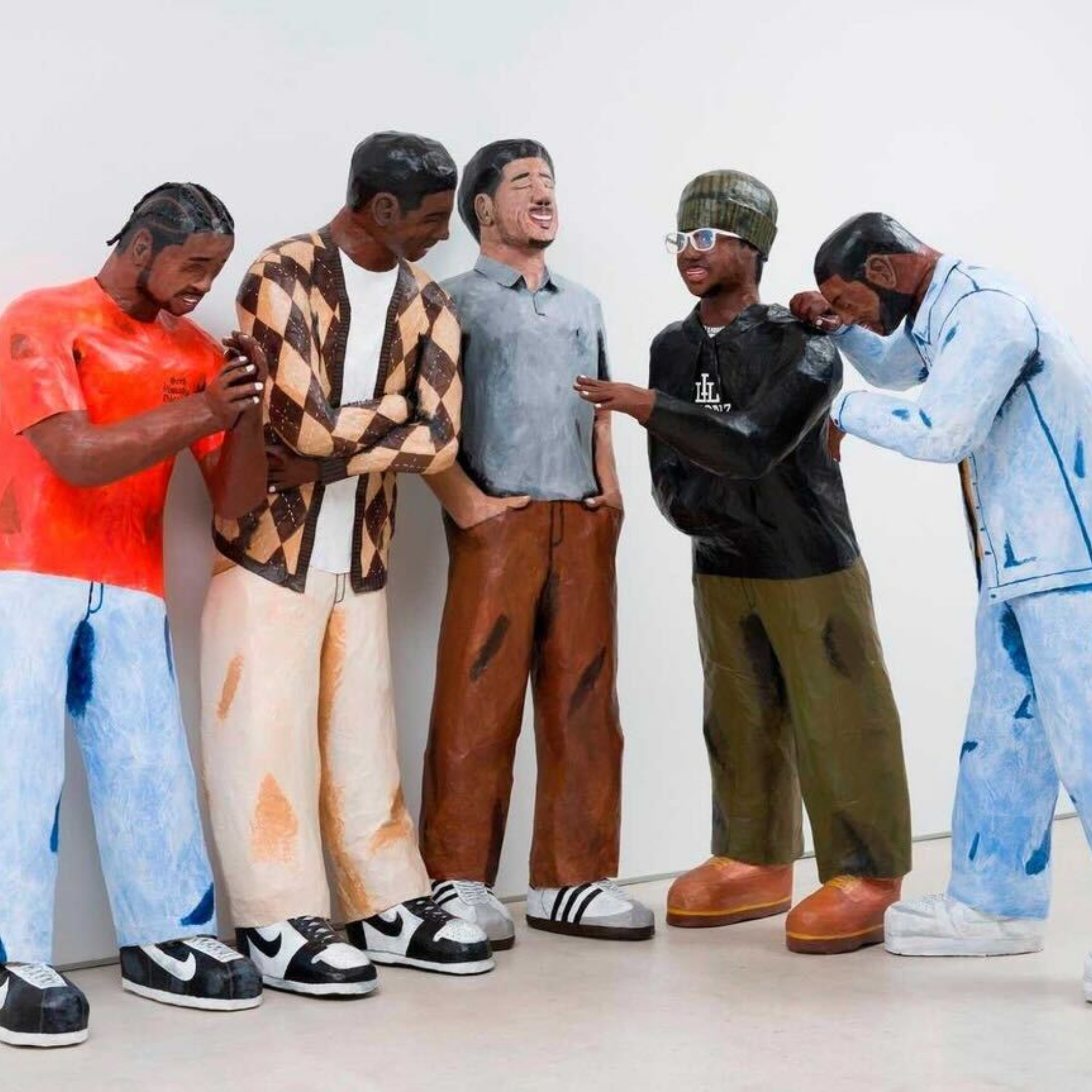 Colorful life-sized sculptures of five people standing together, laughing and chatting