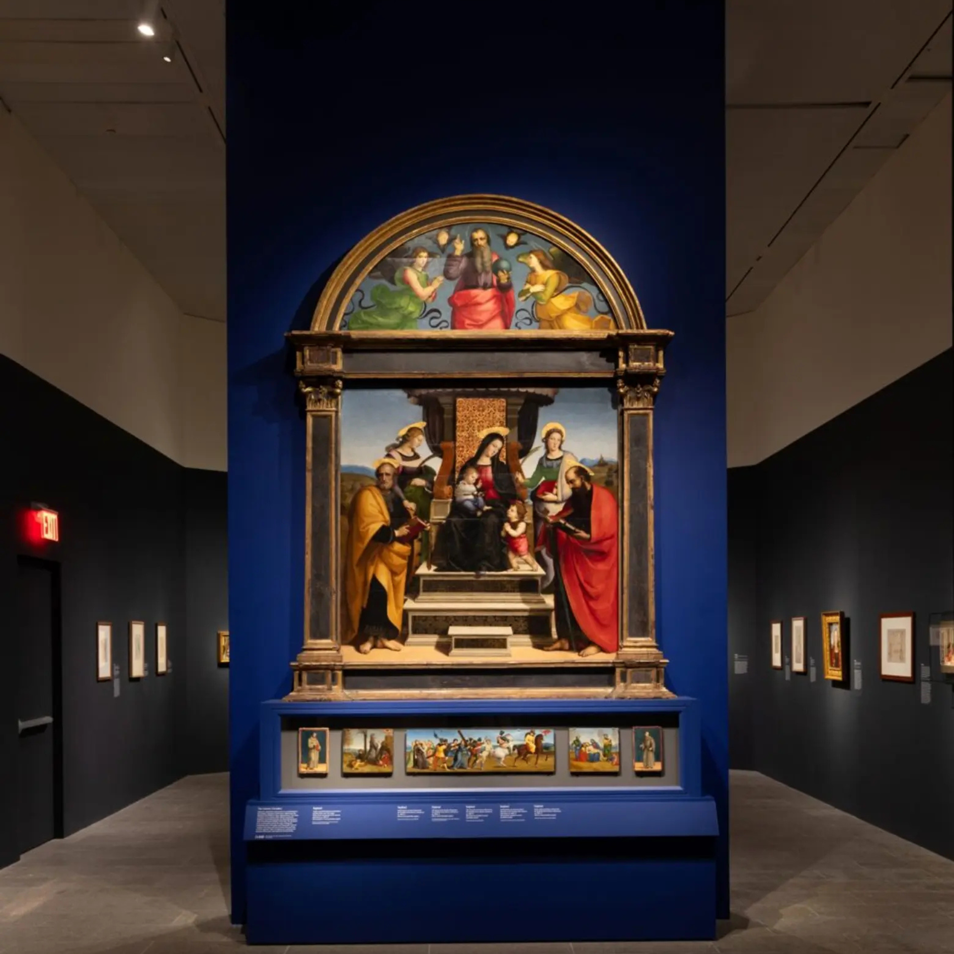 Renaissance altarpiece with Madonna and Child surrounded by saints, displayed in a museum gallery
