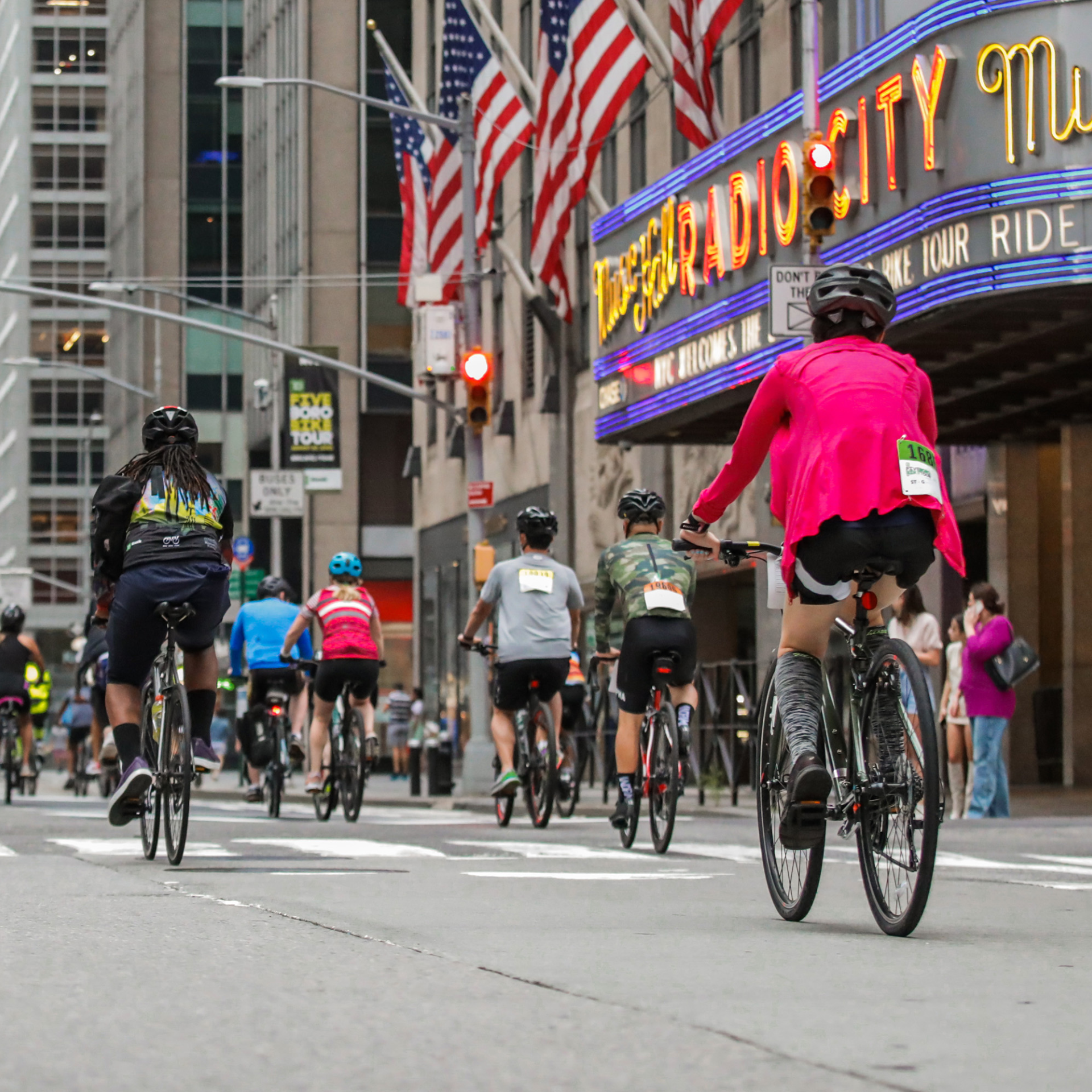 Cyclists ride past the brightly lit Radio City Music Hall in New York City during an organized bike event