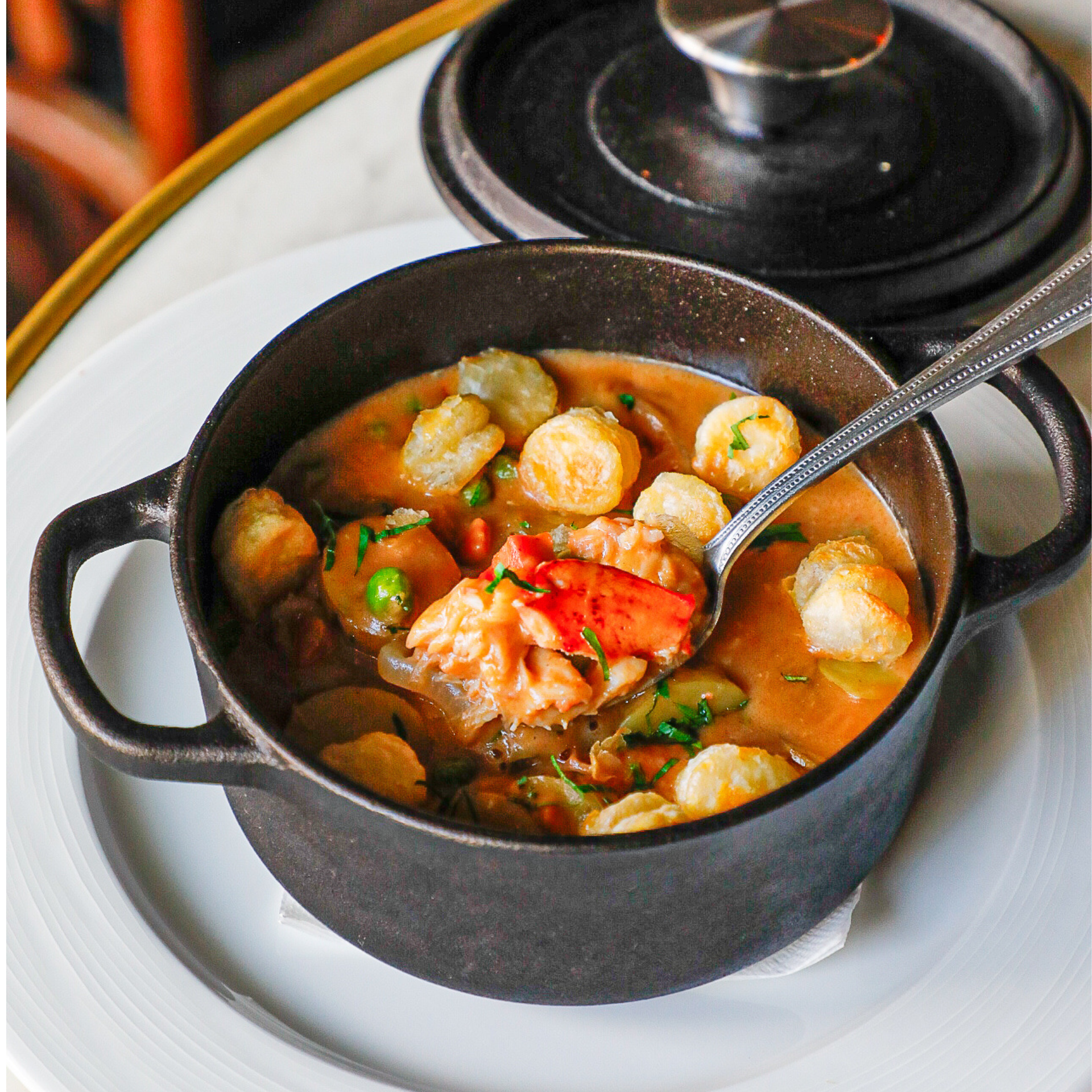 Cast iron pot of lobster stew with spoon