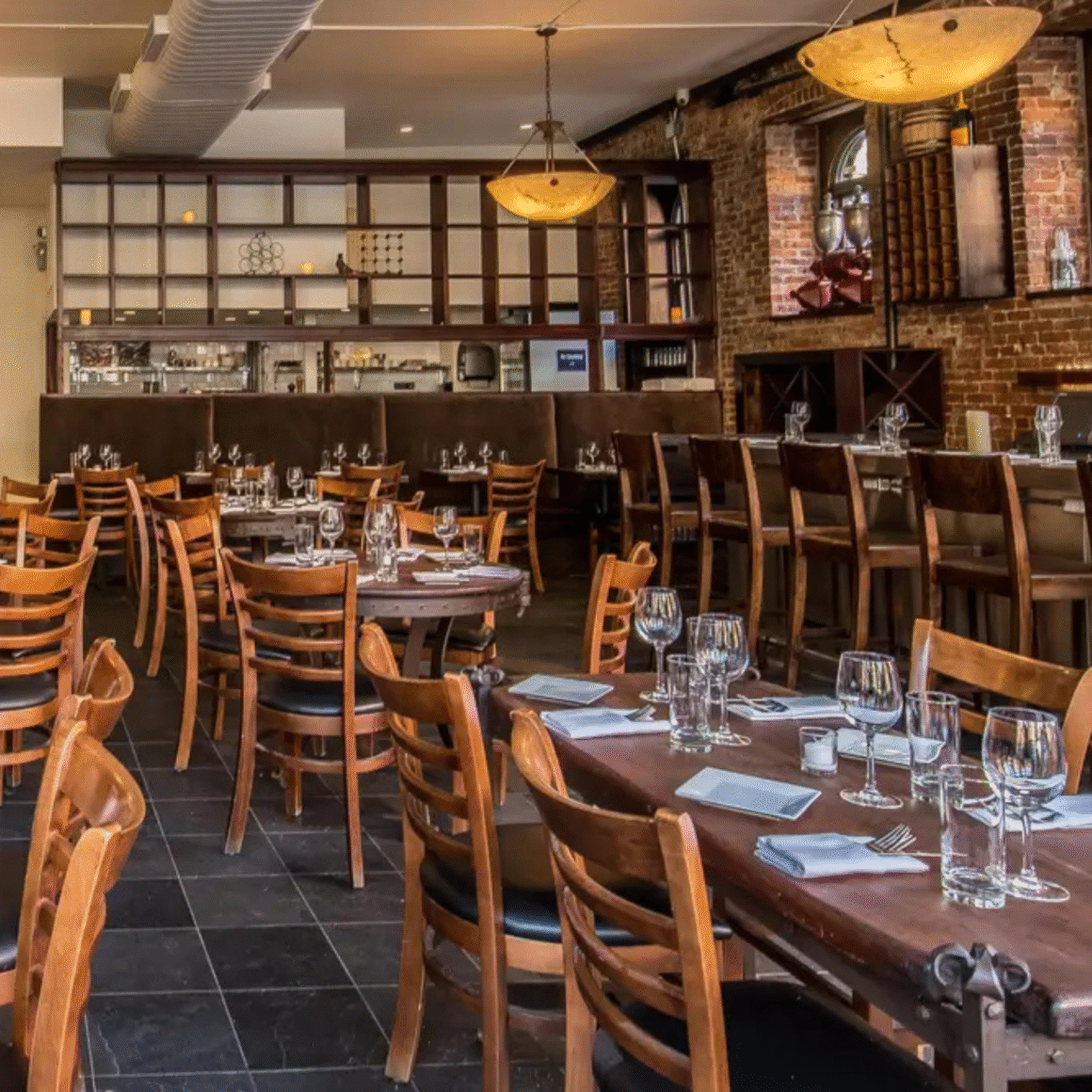 Rustic-modern restaurant interior with wooden tables, exposed brick walls, and warm ambient lighting