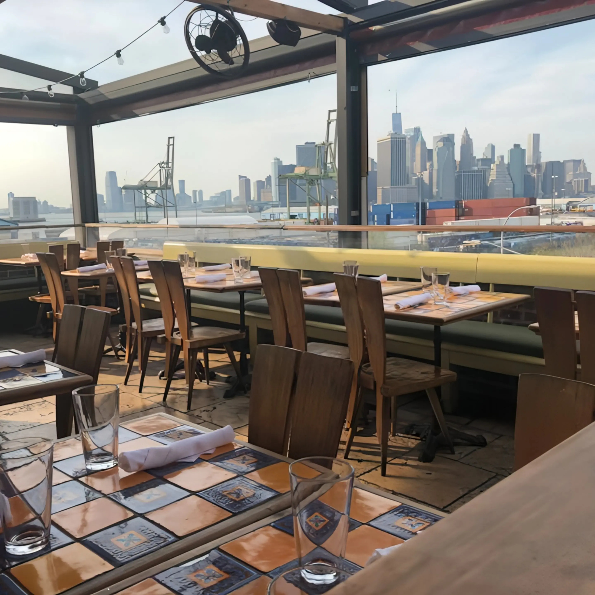 Rooftop restaurant with patterned tables and city skyline view