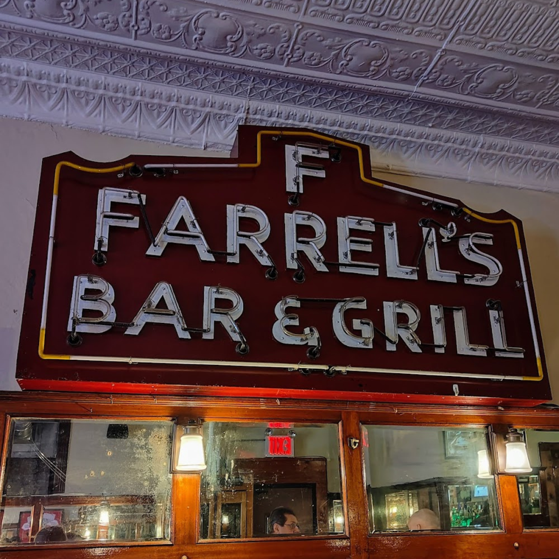 Vintage neon sign for Farrell’s Bar & Grill above a mirror inside the restaurant