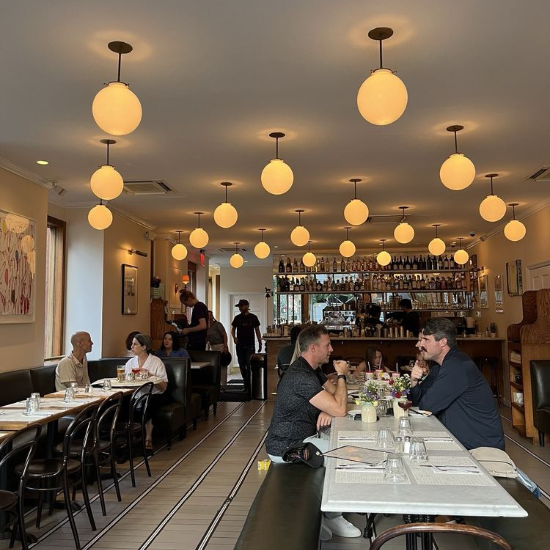 Warmly lit café with communal table and bar area