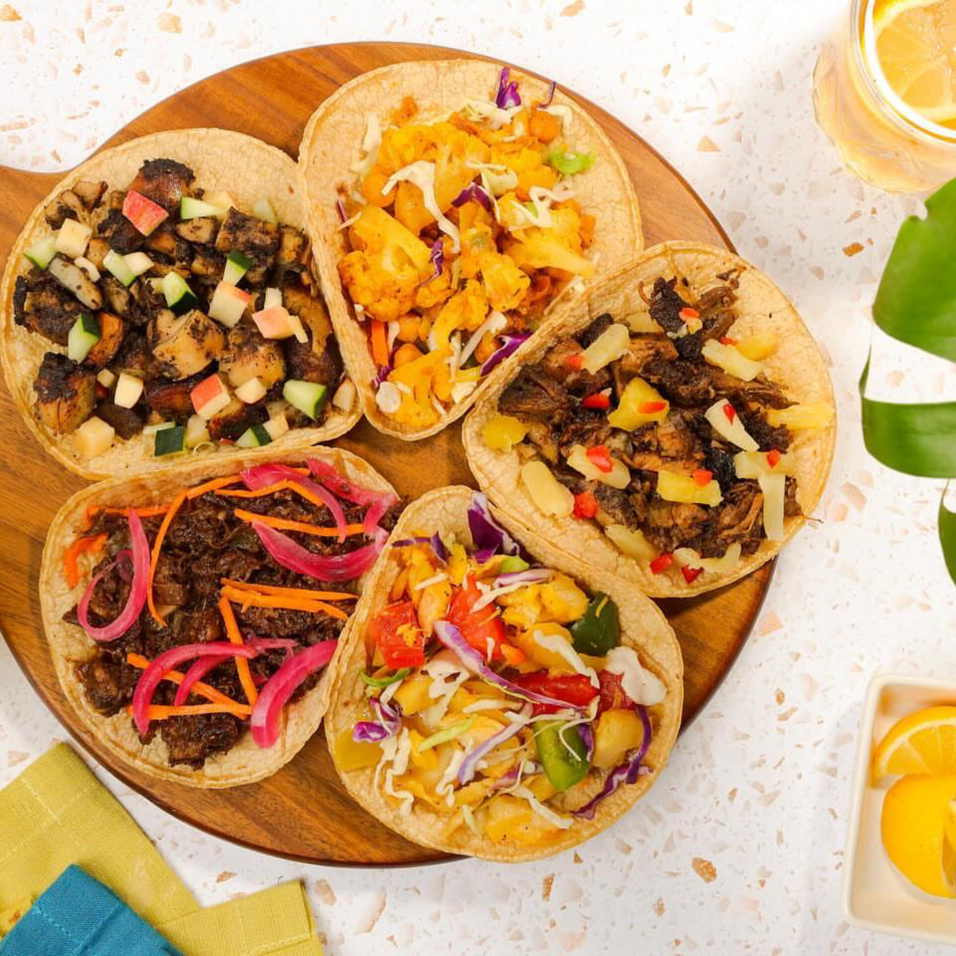 Smorgasburg NYC: Wooden platter with five colorful tacos filled with assorted vegetables and toppings