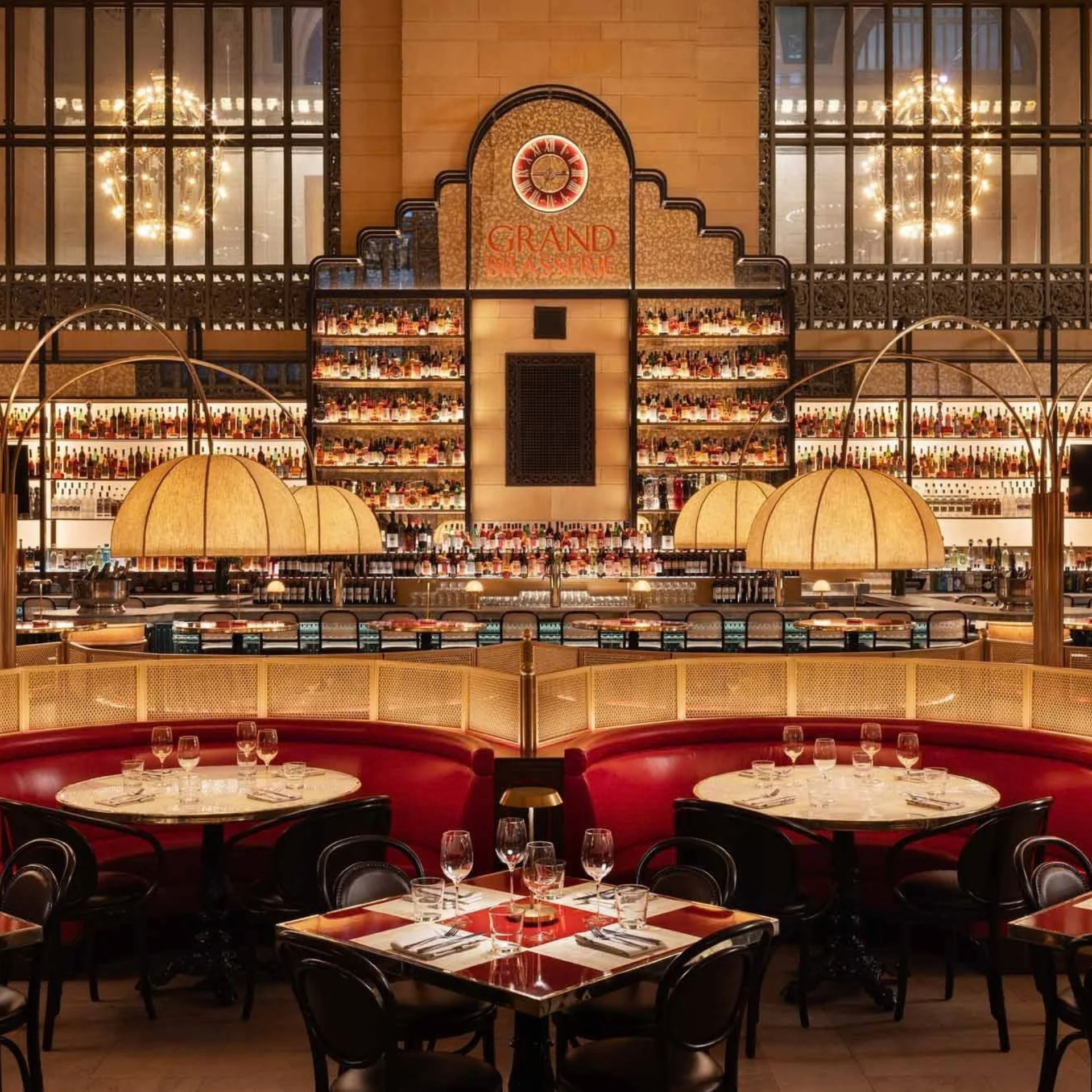 Grand Central Oyster Bar interior with ornate liquor shelves, red leather booths, and warm pendant lighting