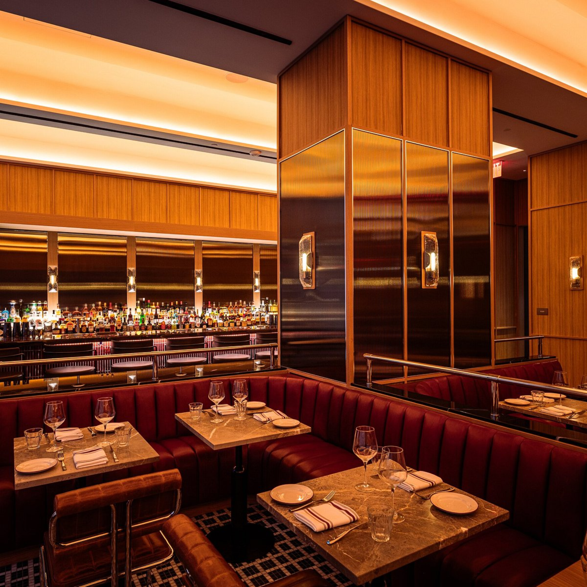 Upscale NYC restaurant with red leather booths, marble tables, and mirrored bar, sophisticated dining and nightlife destination featured in daily things to do in NYC any day