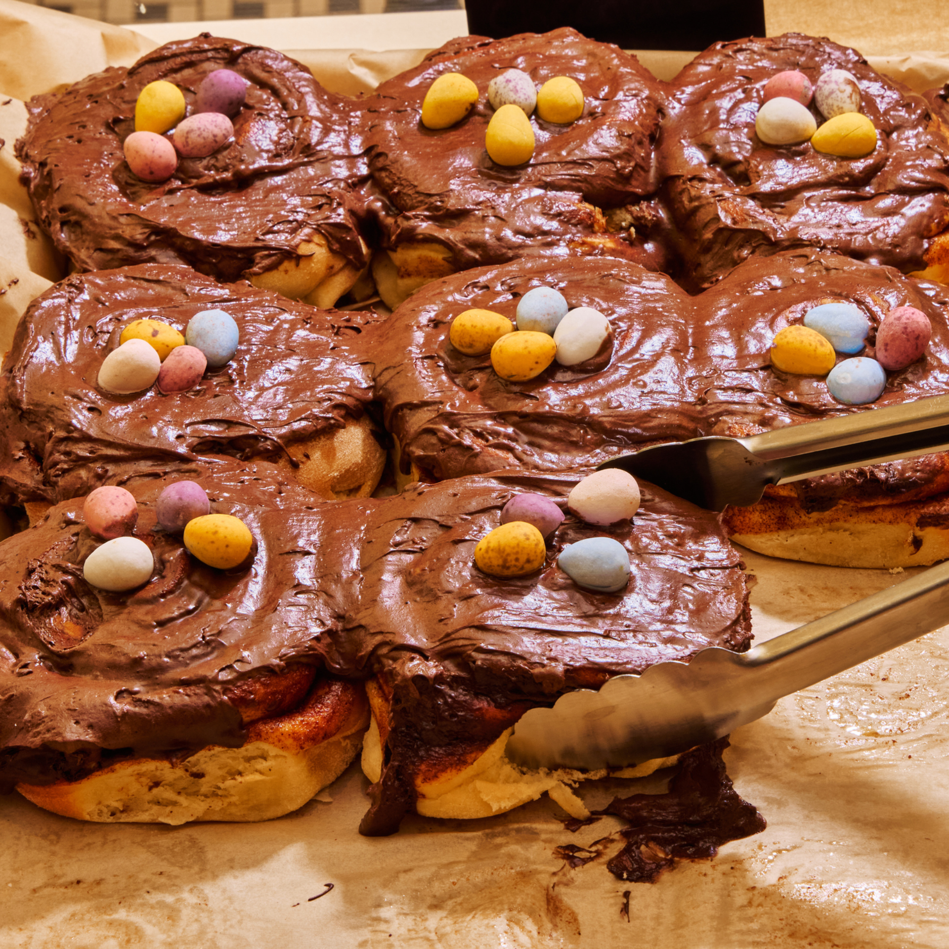 Chocolate‑frosted buns topped with pastel candy eggs