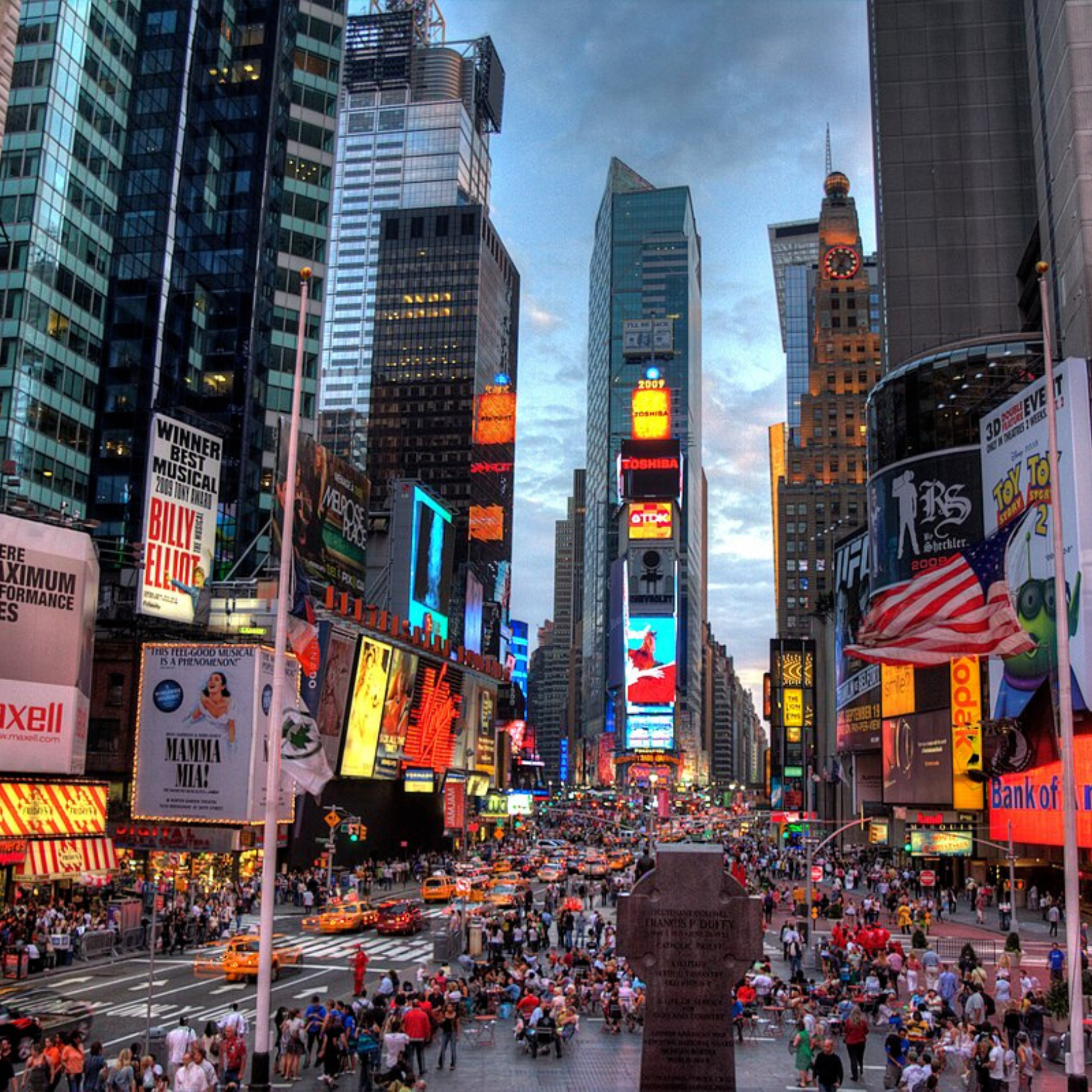 Vibrant Times Square scene with skyscrapers, electronic billboards, American flag, and Broadway ads