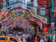 alt="Feast of San Gennaro celebration in Little Italy NYC with festive lights, crowds, Italian eateries, and city traffic"