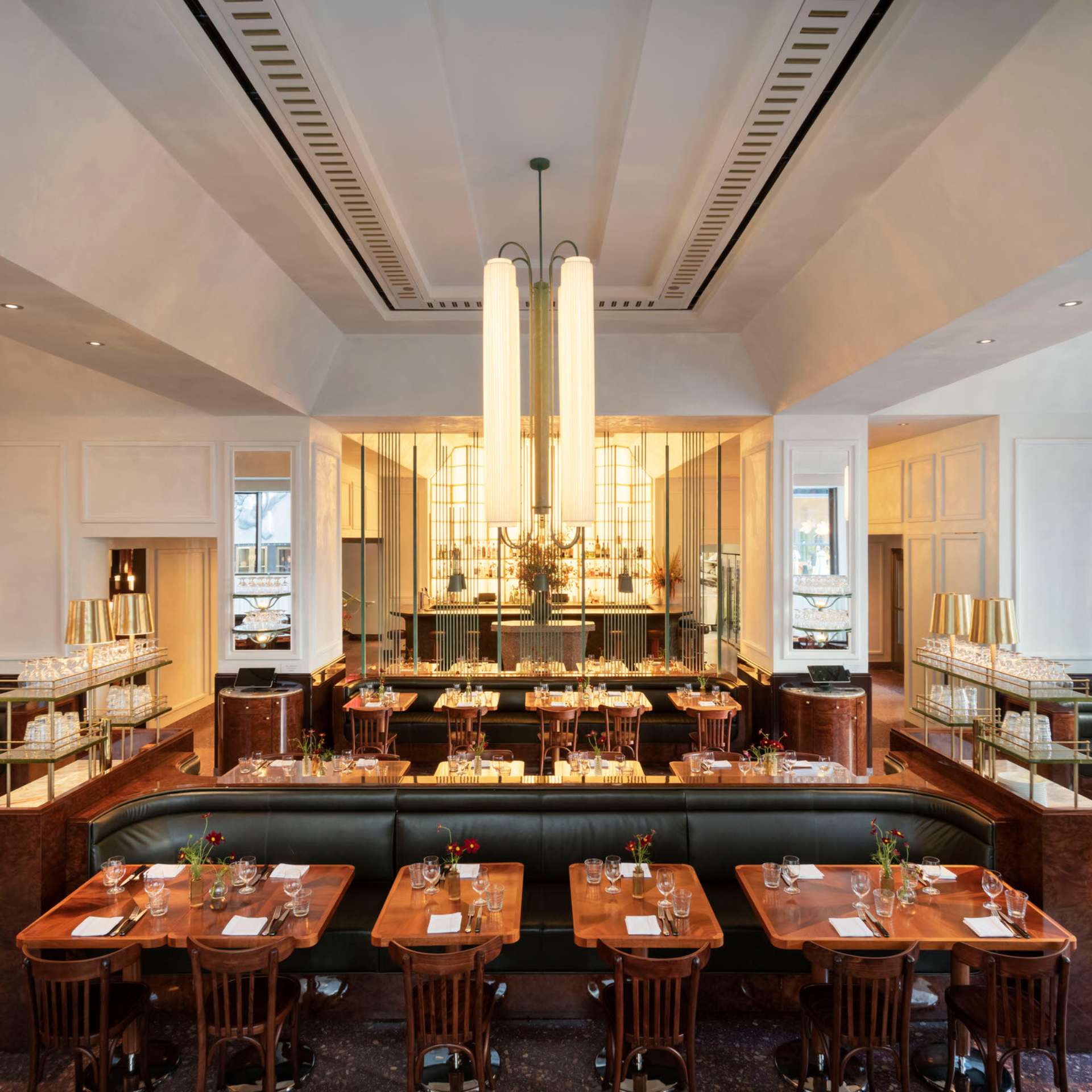 Elegant restaurant interior with Art Deco-inspired design, chandelier, and stylish dining setup