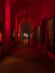 NYC art exhibition hallway with red lighting, abstract fiery artworks on walls, spotlights, and dramatic immersive atmosphere, cultural gallery experience featured in daily things to do in NYC any day