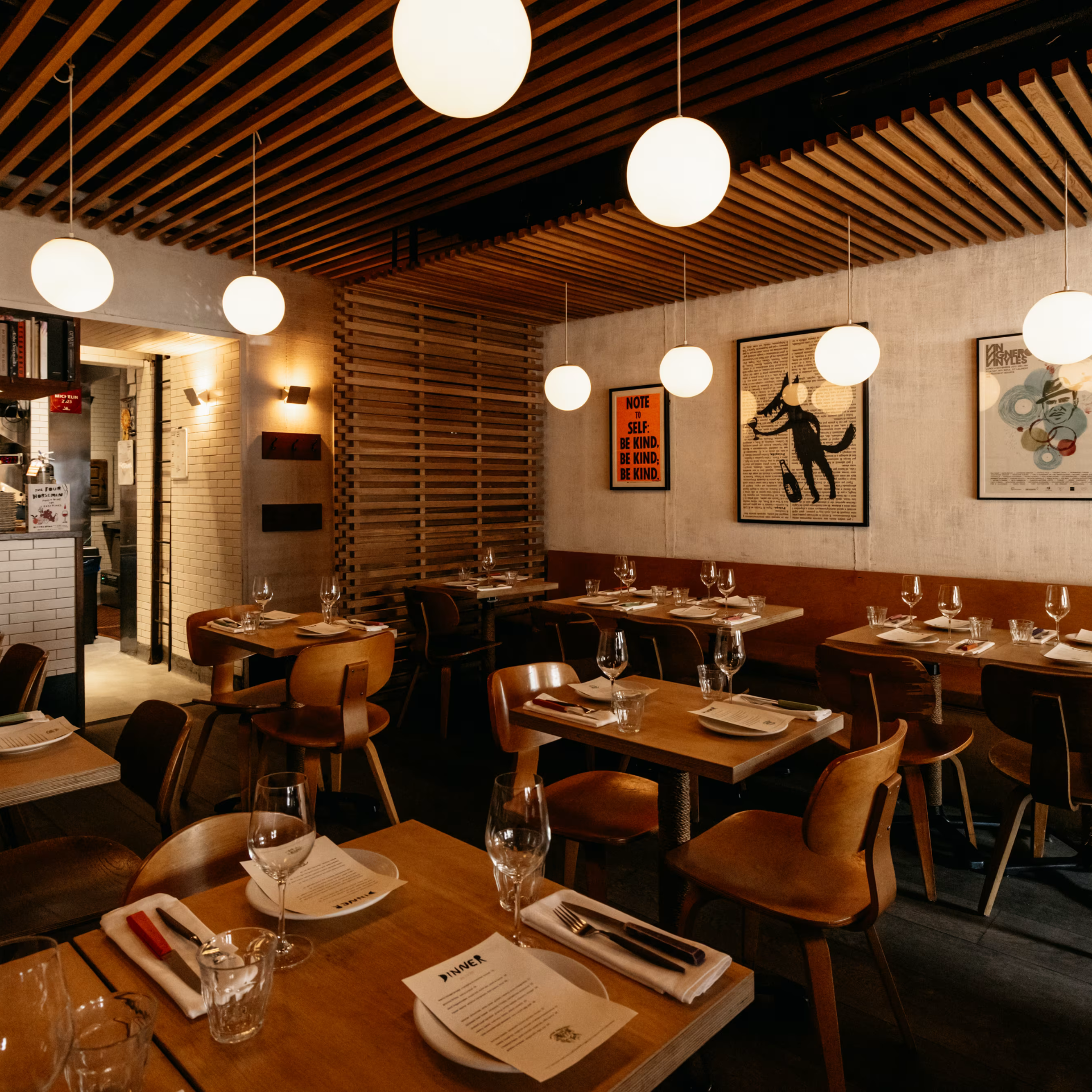 Stylish restaurant with wood paneling, soft pendant lights, marble tables, and cozy seating set for guests in warm ambiance
