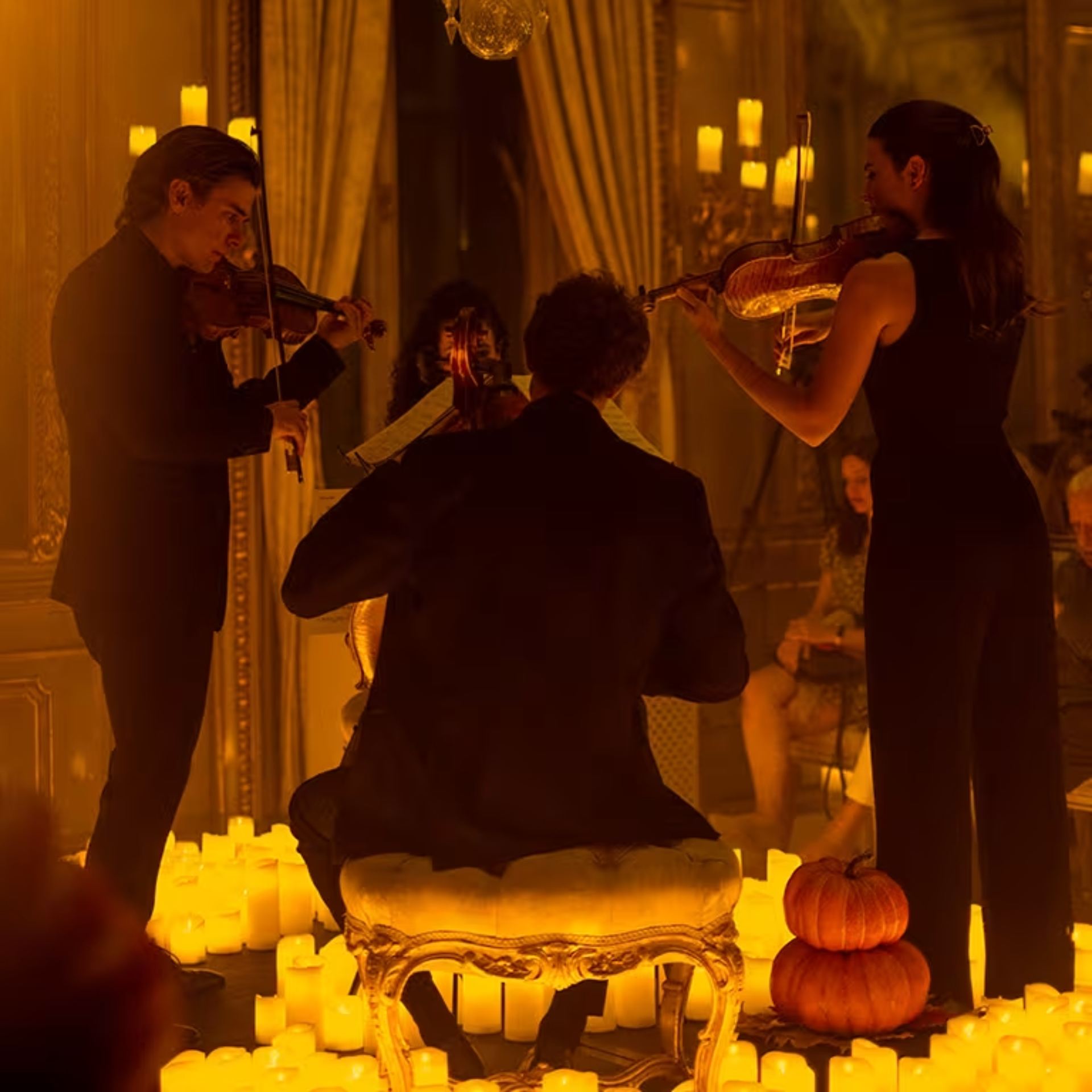 Musicians play strings surrounded by candles in elegant room