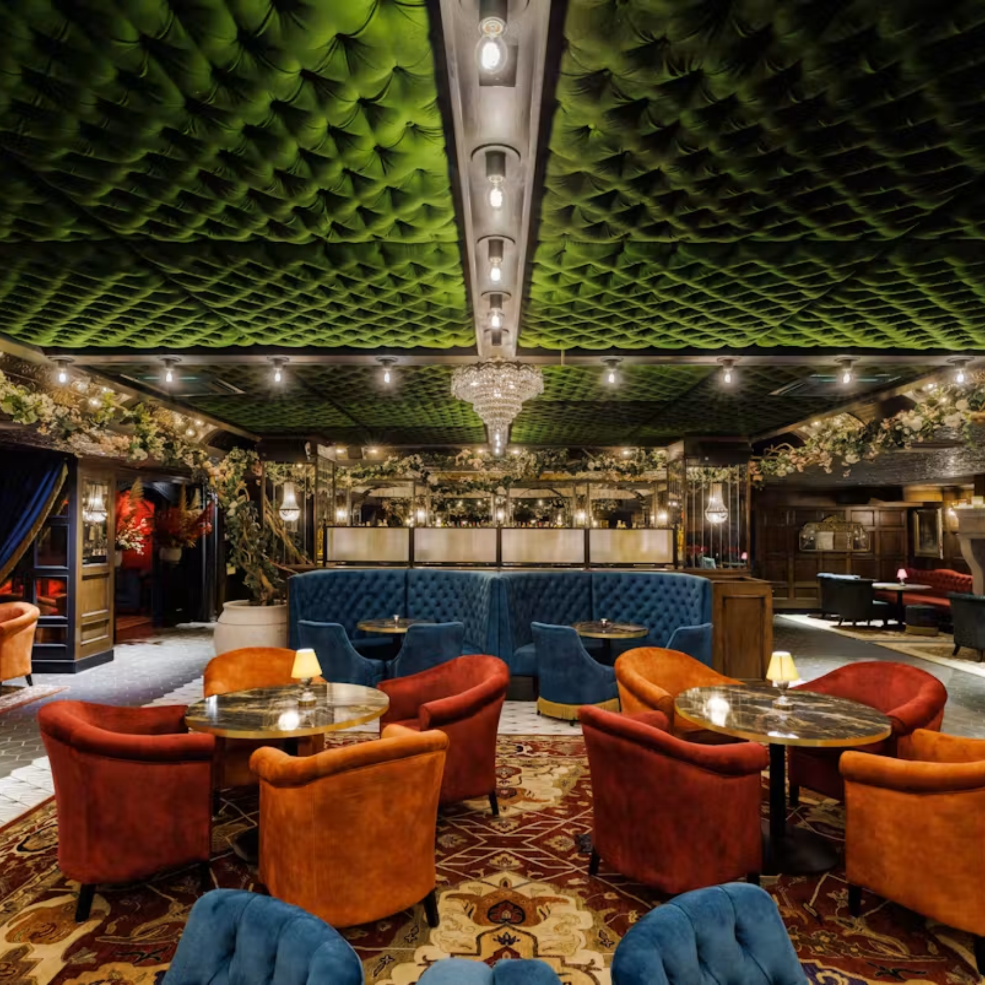 Luxurious lounge with tufted green ceiling and velvet seating