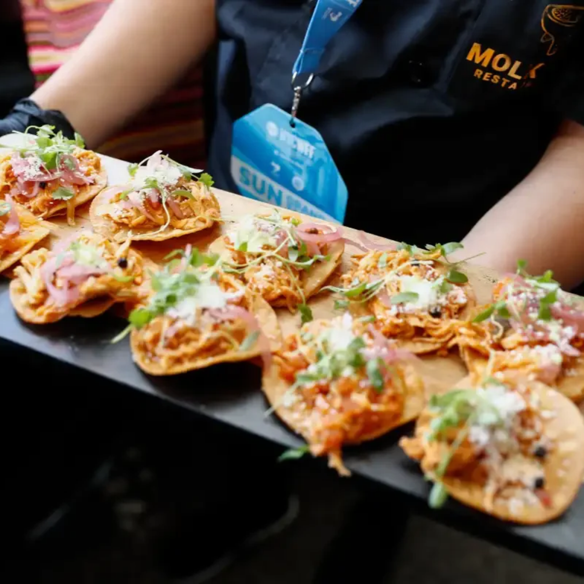 Tray of small tostadas with meat, onions, and microgreens