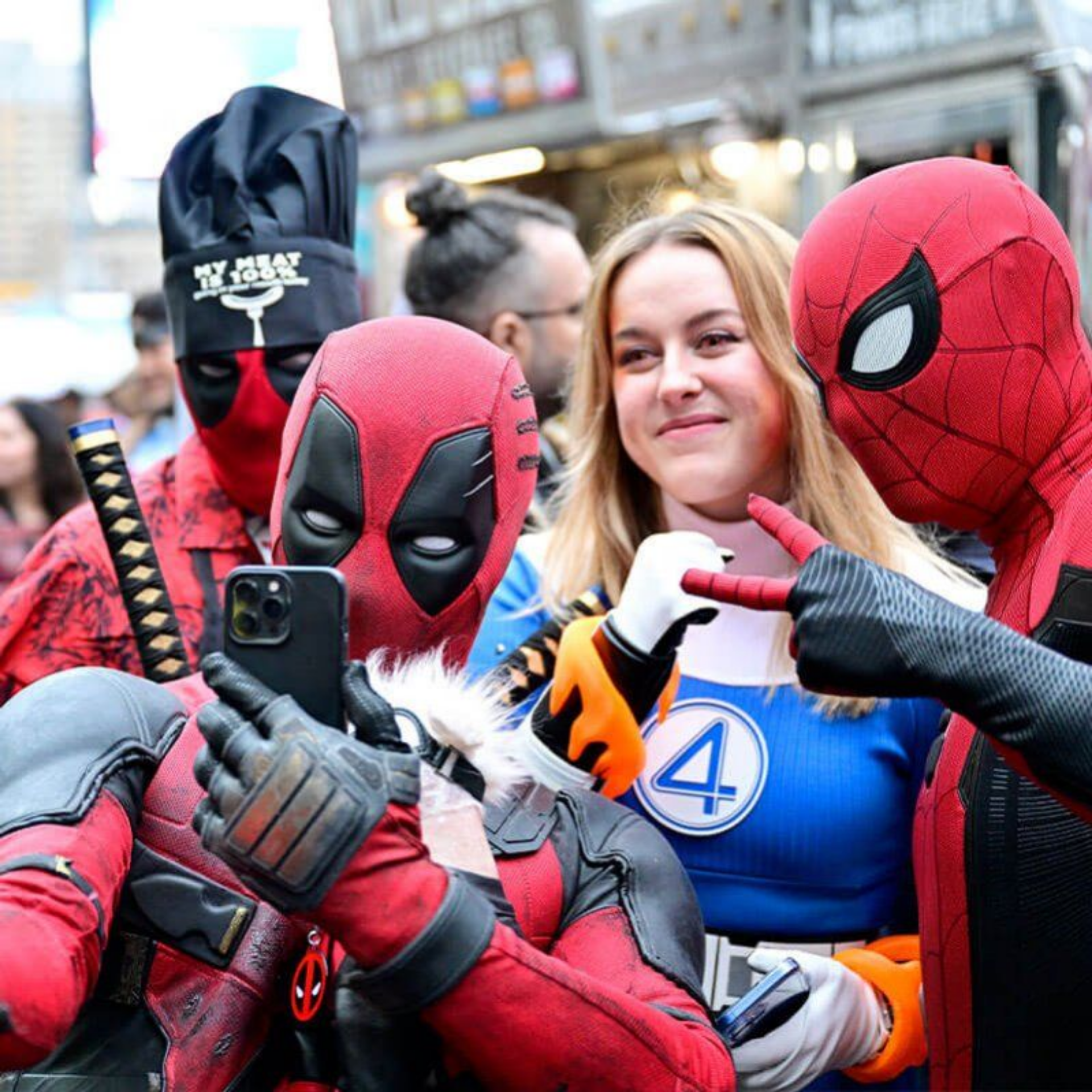 Group in Deadpool, Spider‑Man, and Fantastic Four costumes posing for selfie