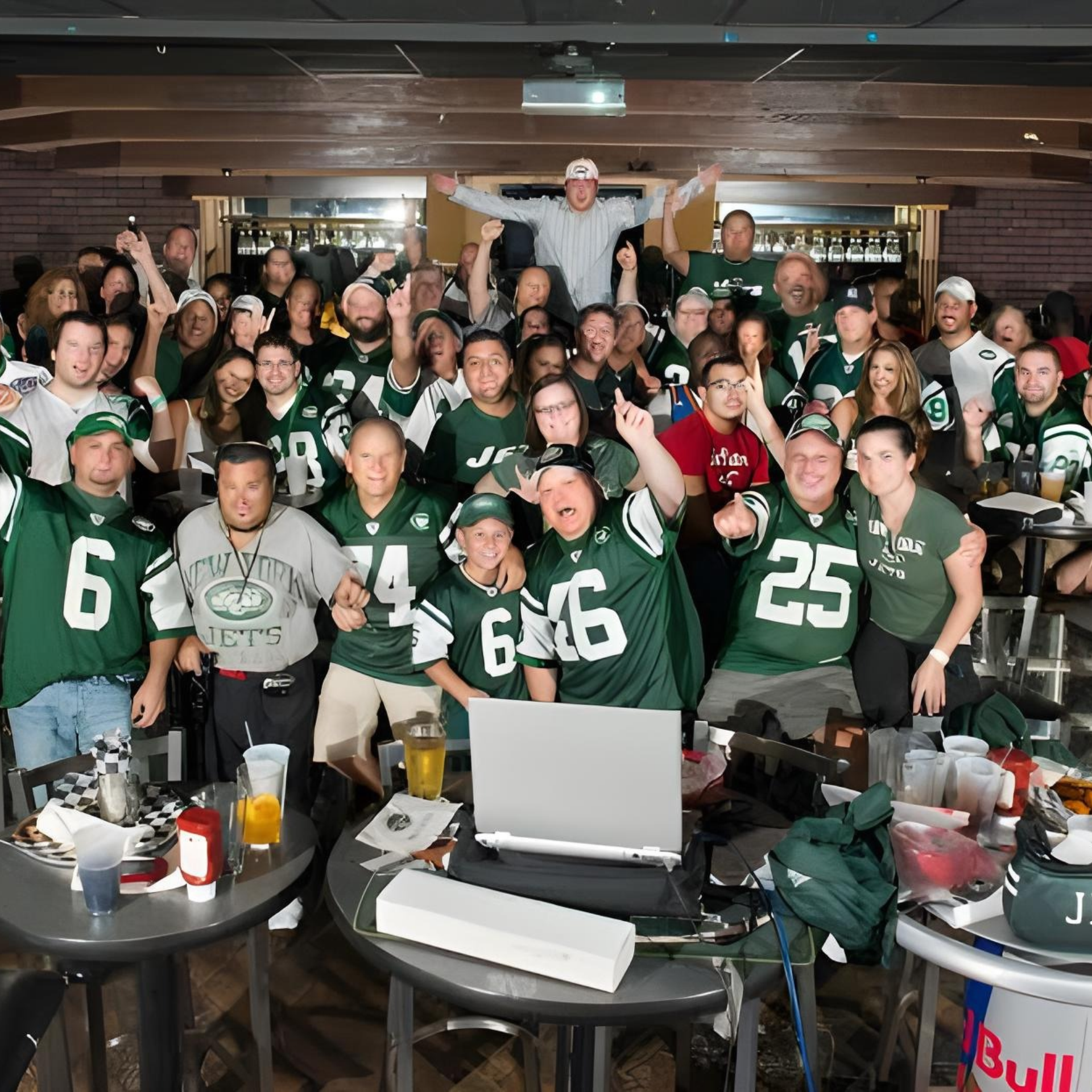 Group in New York Jets jerseys cheering at bar event