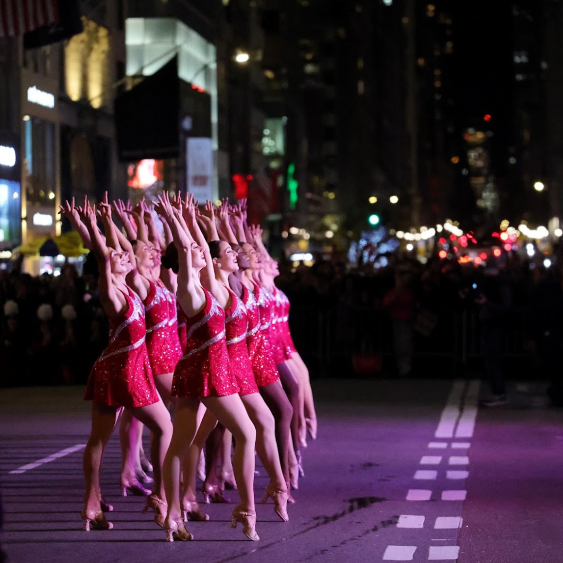 A Group of dancer dancing in the middle of road performing at night