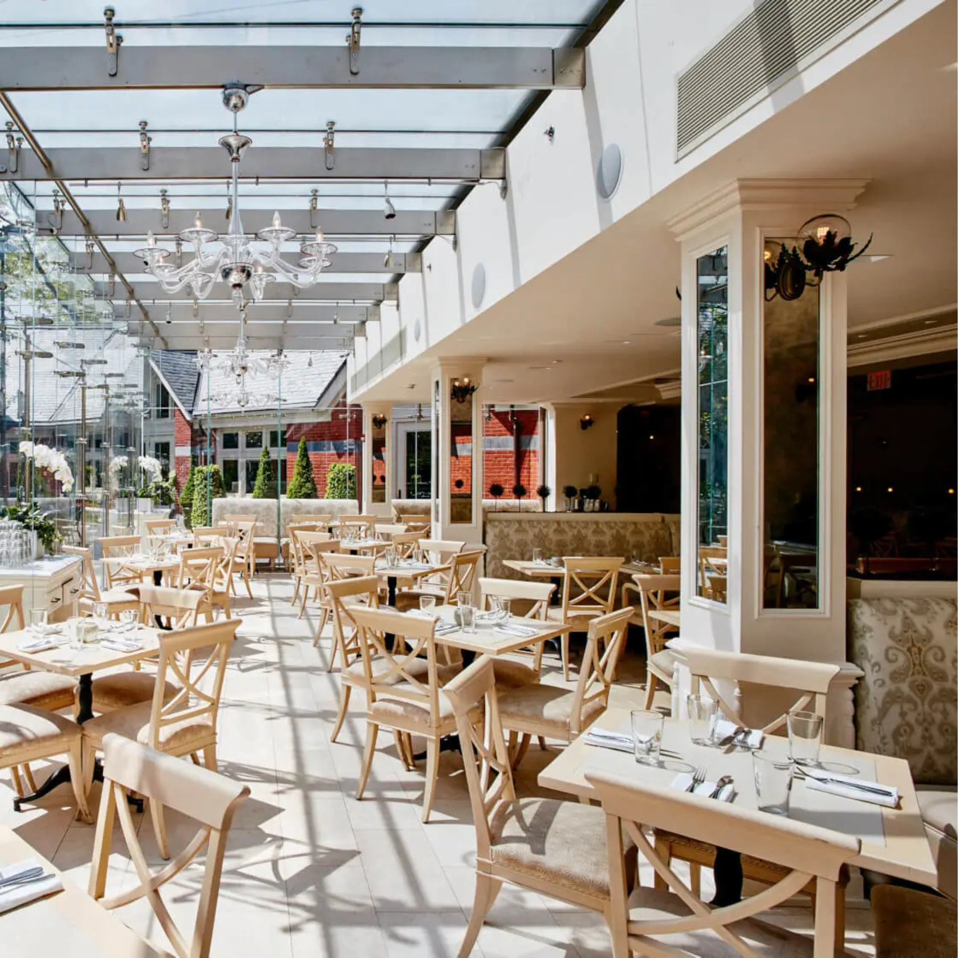 Bright restaurant interior with glass ceiling, natural light, and neatly set tables