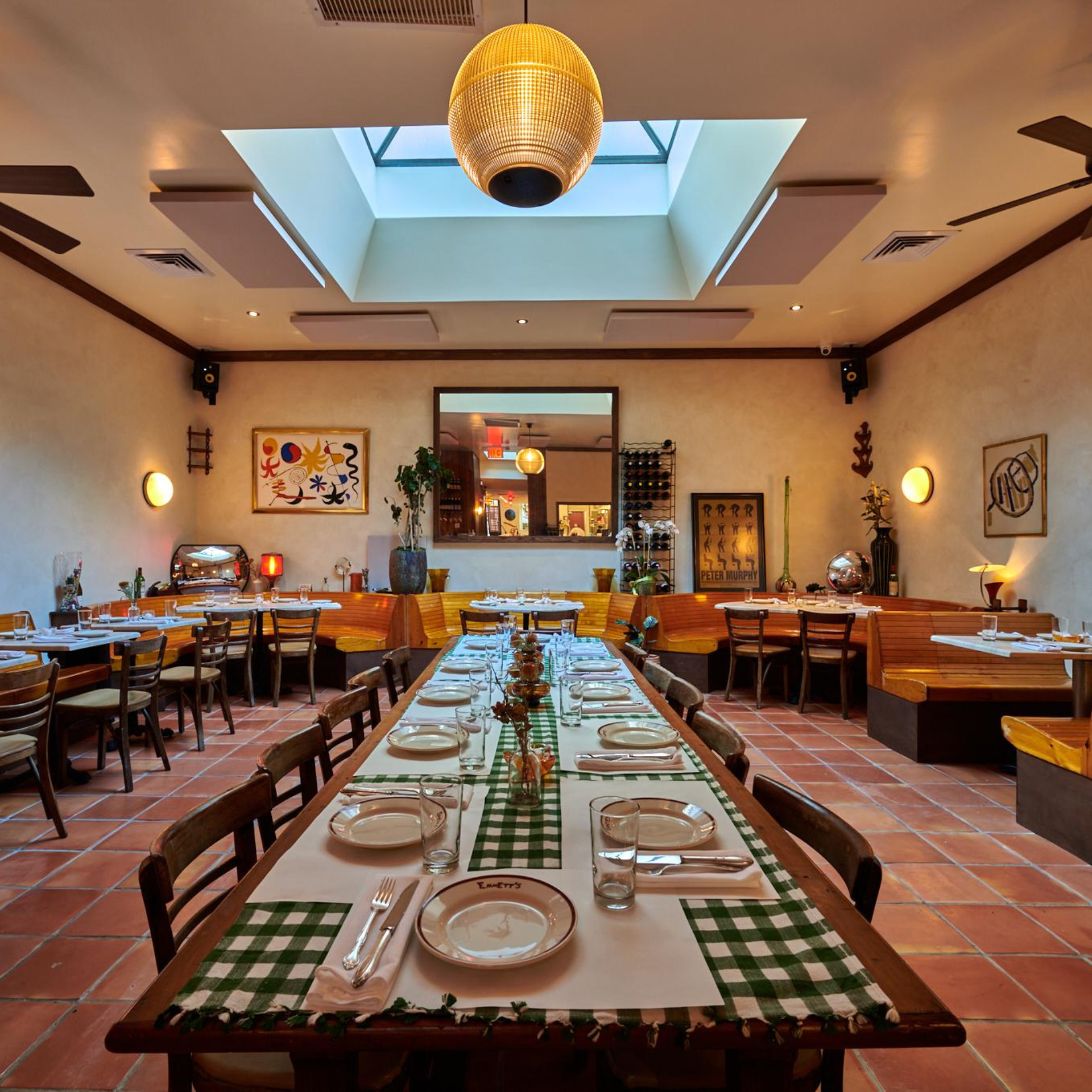 Warm dining space featuring checkered table runners, floral centerpieces, and terracotta tiles