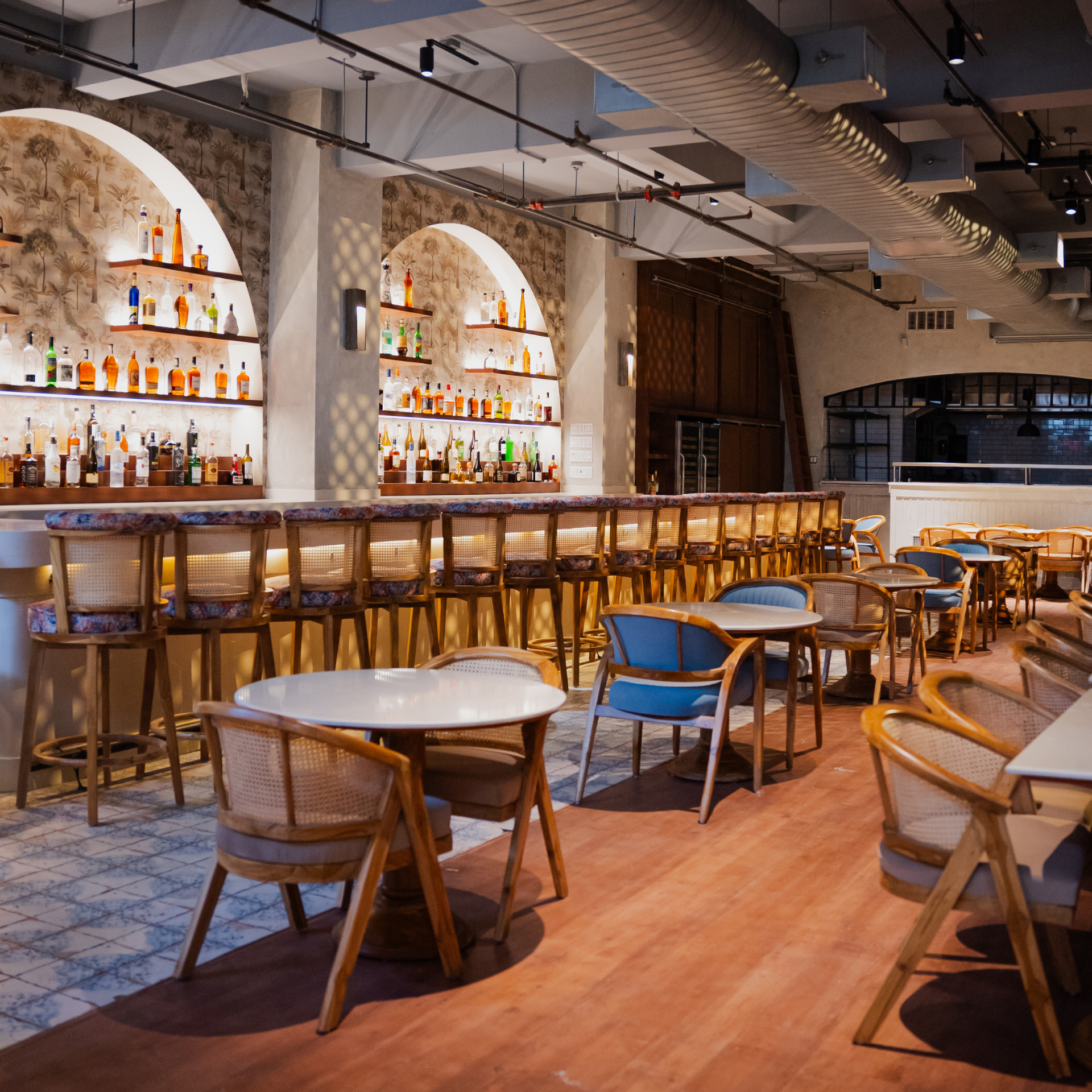 New Restaurant Openings in NYC: Stylish bar interior with arched liquor shelves, marble counter, and mixed seating