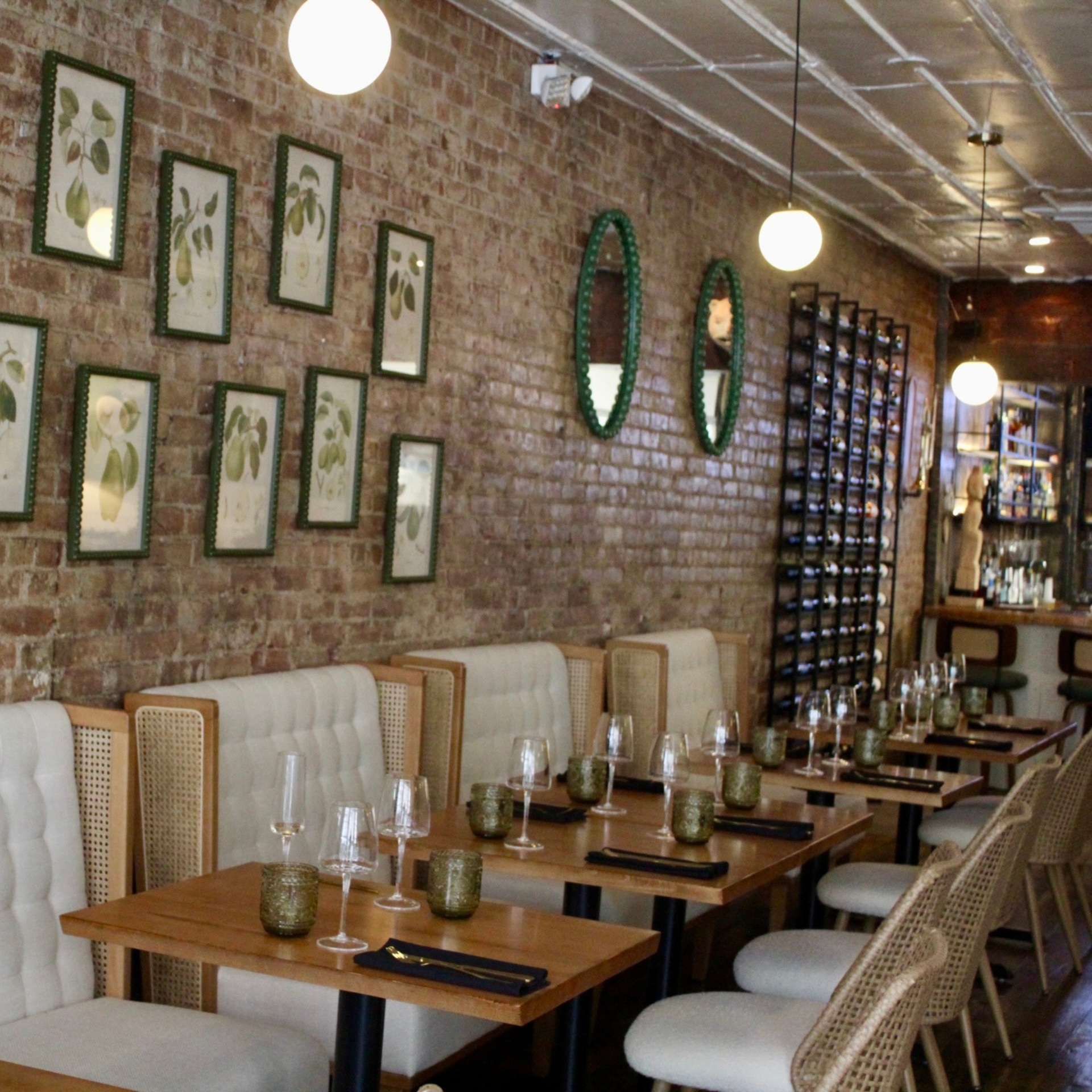 Elegant restaurant interior with wooden tables, brick wall, and warm lighting
