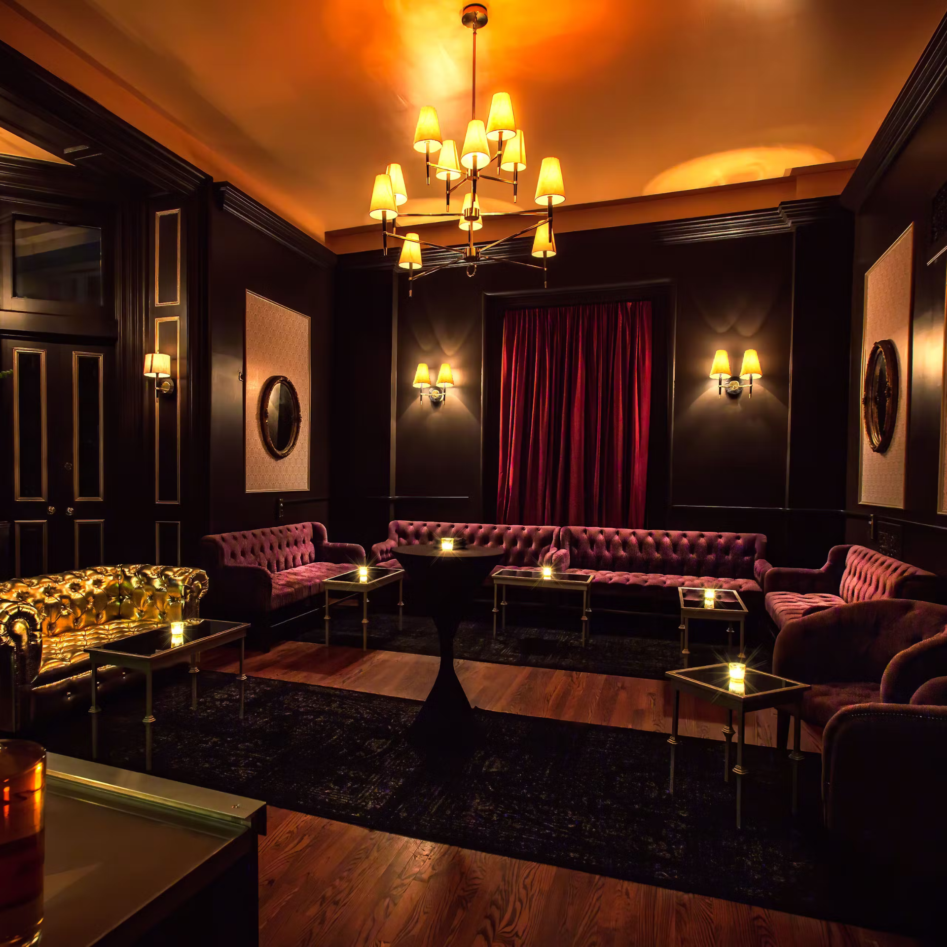 Elegant lounge with tufted sofas, gold accents, and warm ambient lighting