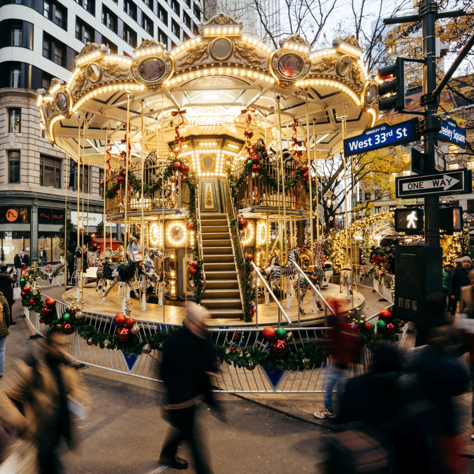 Holiday carousel decorated with garlands and ornaments at West 33rd Street and Greeley Square in NYC