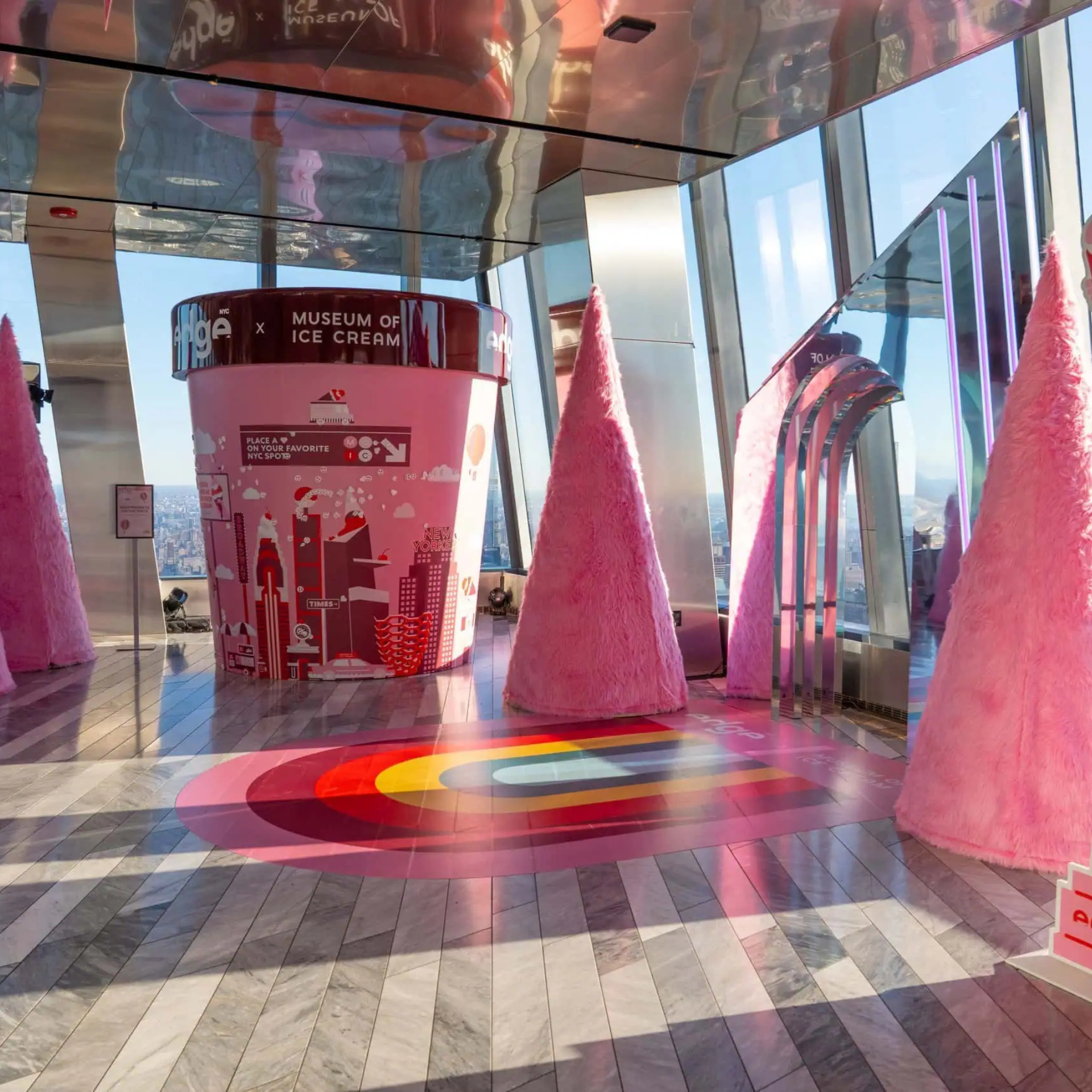 Colorful Museum of Ice Cream exhibit with pink ice cream tub, fuzzy cones, and rainbow floor