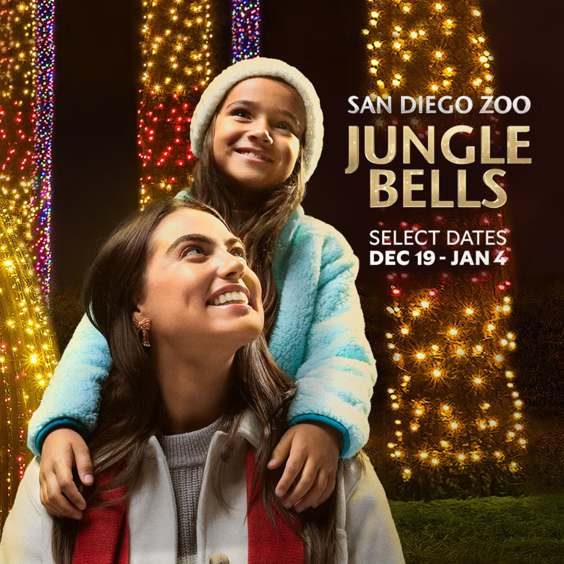Smiling woman carrying a child on her shoulders at San Diego Zoo’s 'Jungle Bells' holiday lights event