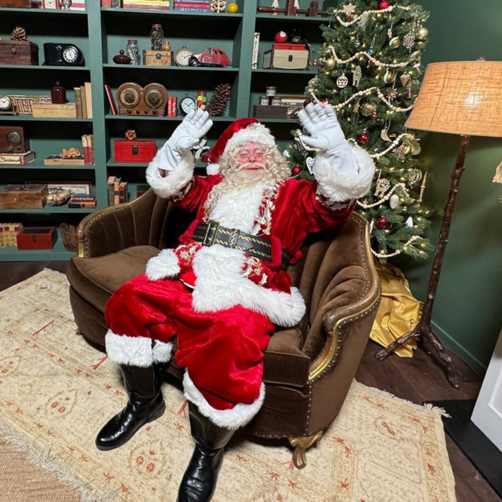 Santa Claus sitting cheerfully in a festive room with a decorated Christmas tree and vintage shelves