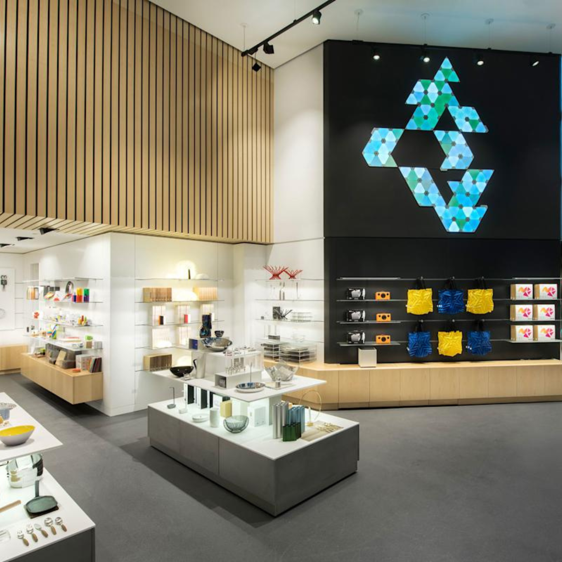 NYC Things To Do this Week: Contemporary gift shop interior with shelves of books, colorful bags, and a striking hexagonal light installation