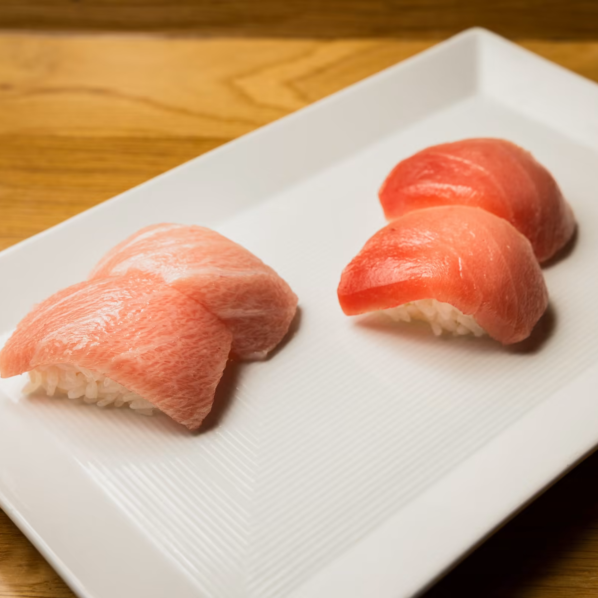 Nigiri sushi platter with fatty tuna otoro and lean tuna akami served on a white rectangular plate