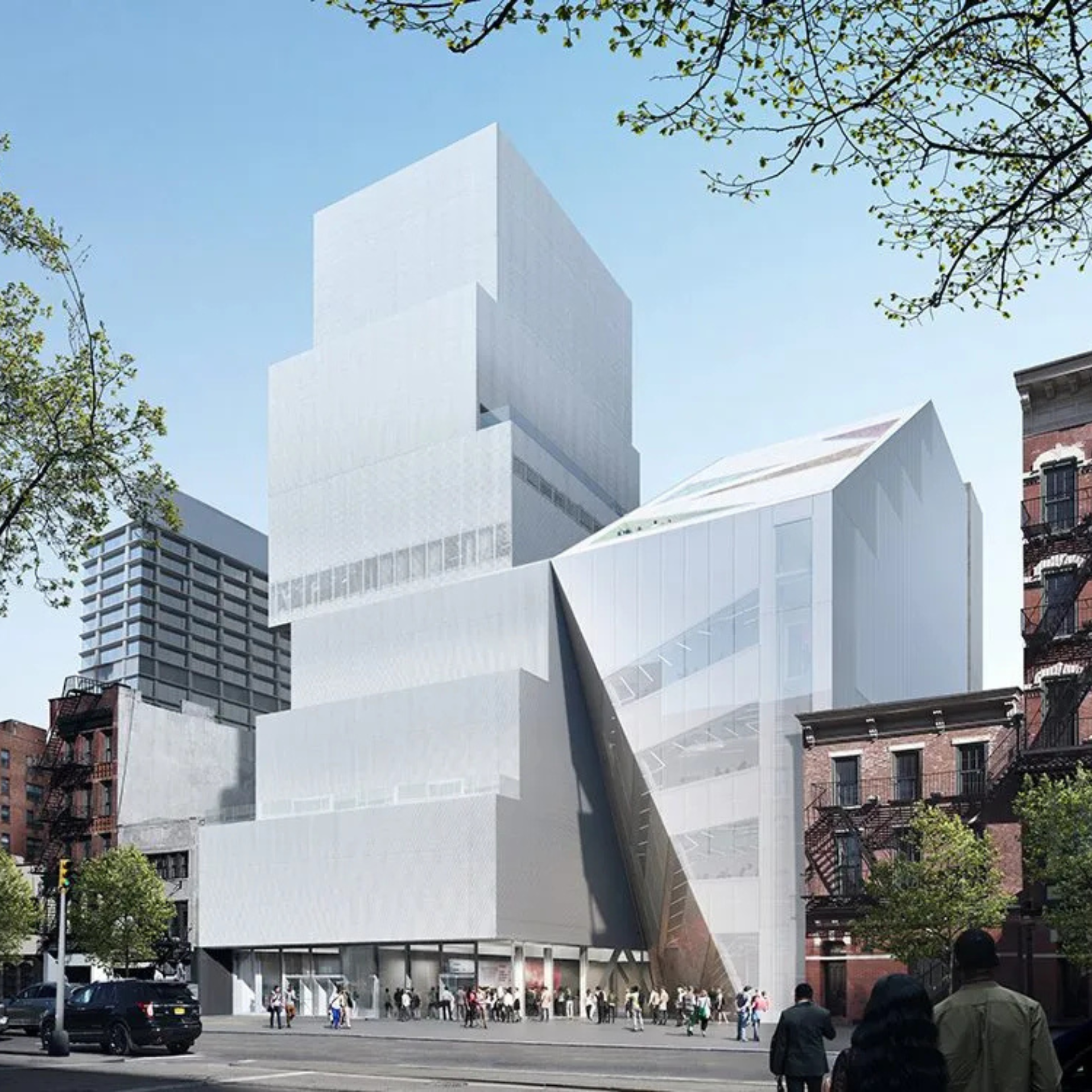 Modern white and glass building with stacked, offset rectangular volumes contrasts with surrounding brick architecture, as people gather at its entrance under a clear blue sky