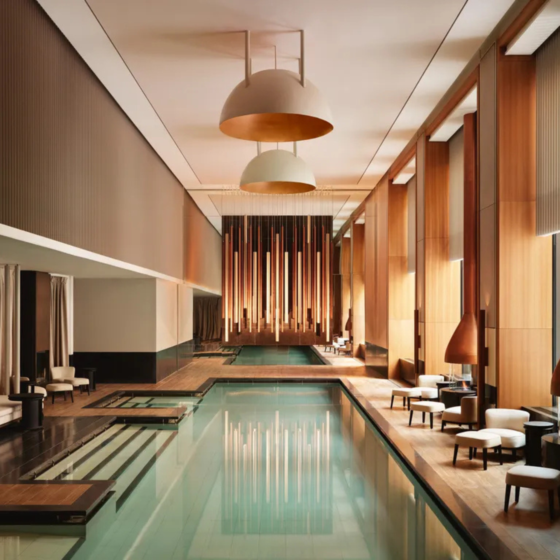 Luxurious indoor pool with lounge chairs and modern lighting