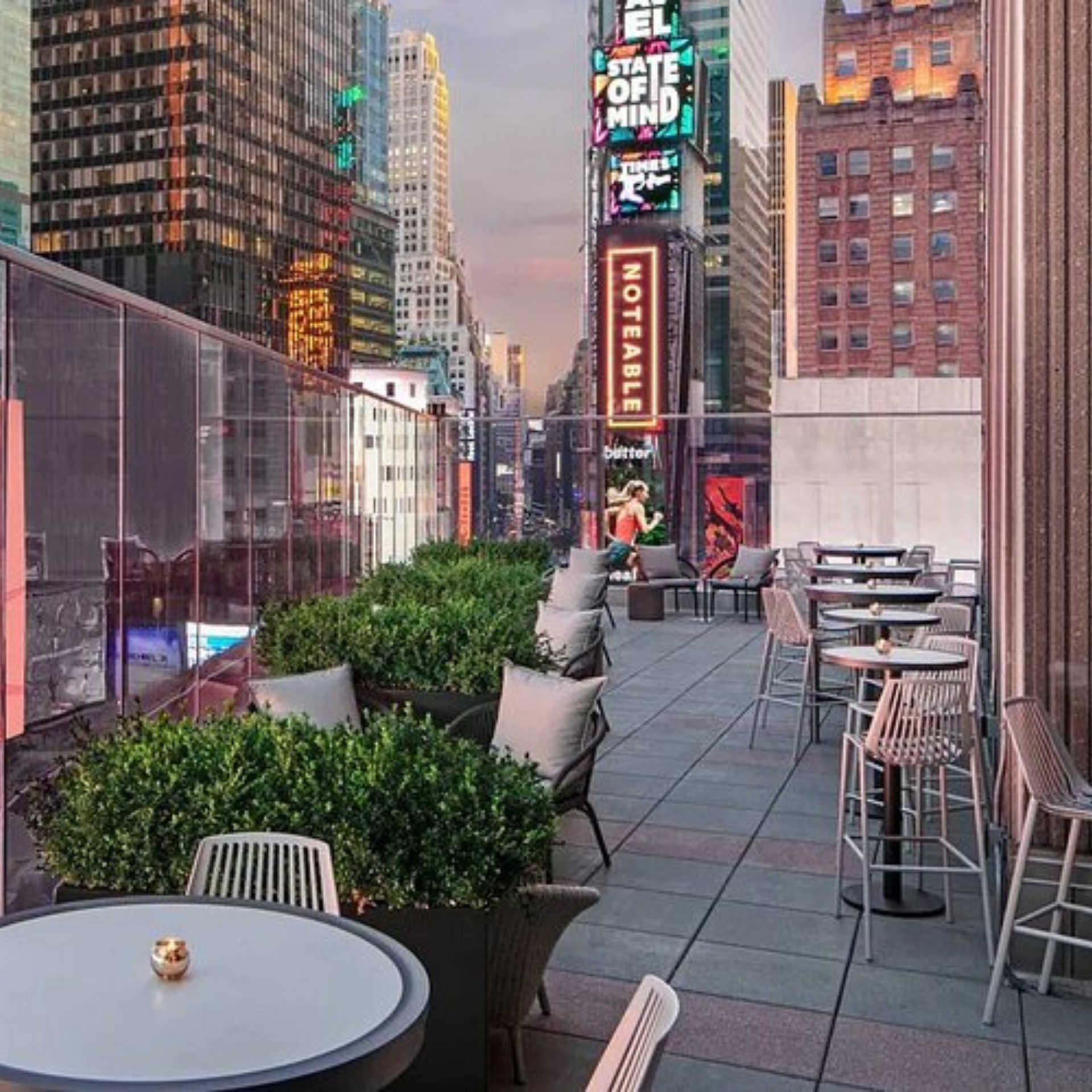 Rooftop terrace with modern seating overlooking Times Square billboards