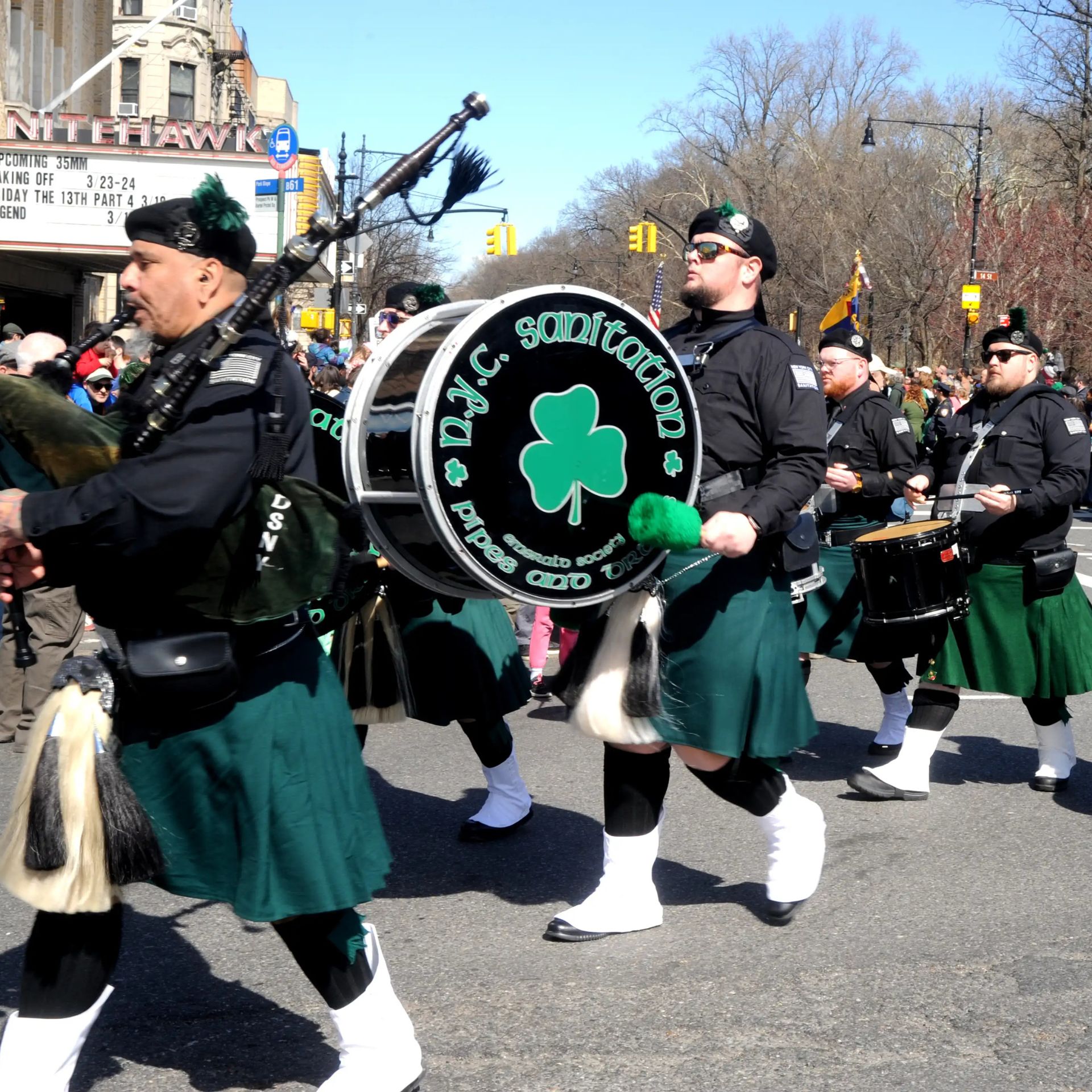 Marching band in green kilts plays bagpipes and drums during a St. Patrick’s Day parade in NYC