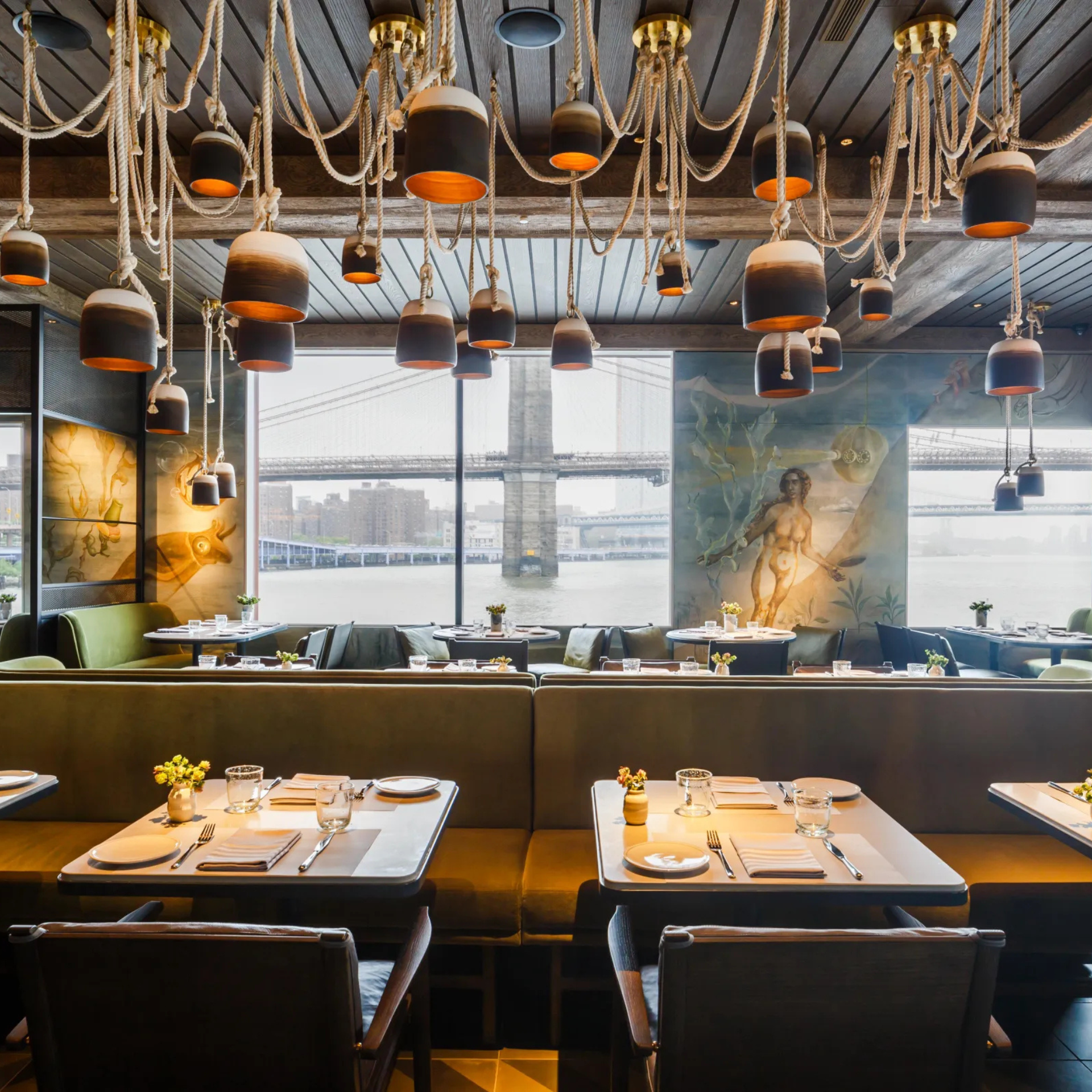 Stylish restaurant interior with rope pendant lights and view of a large bridge