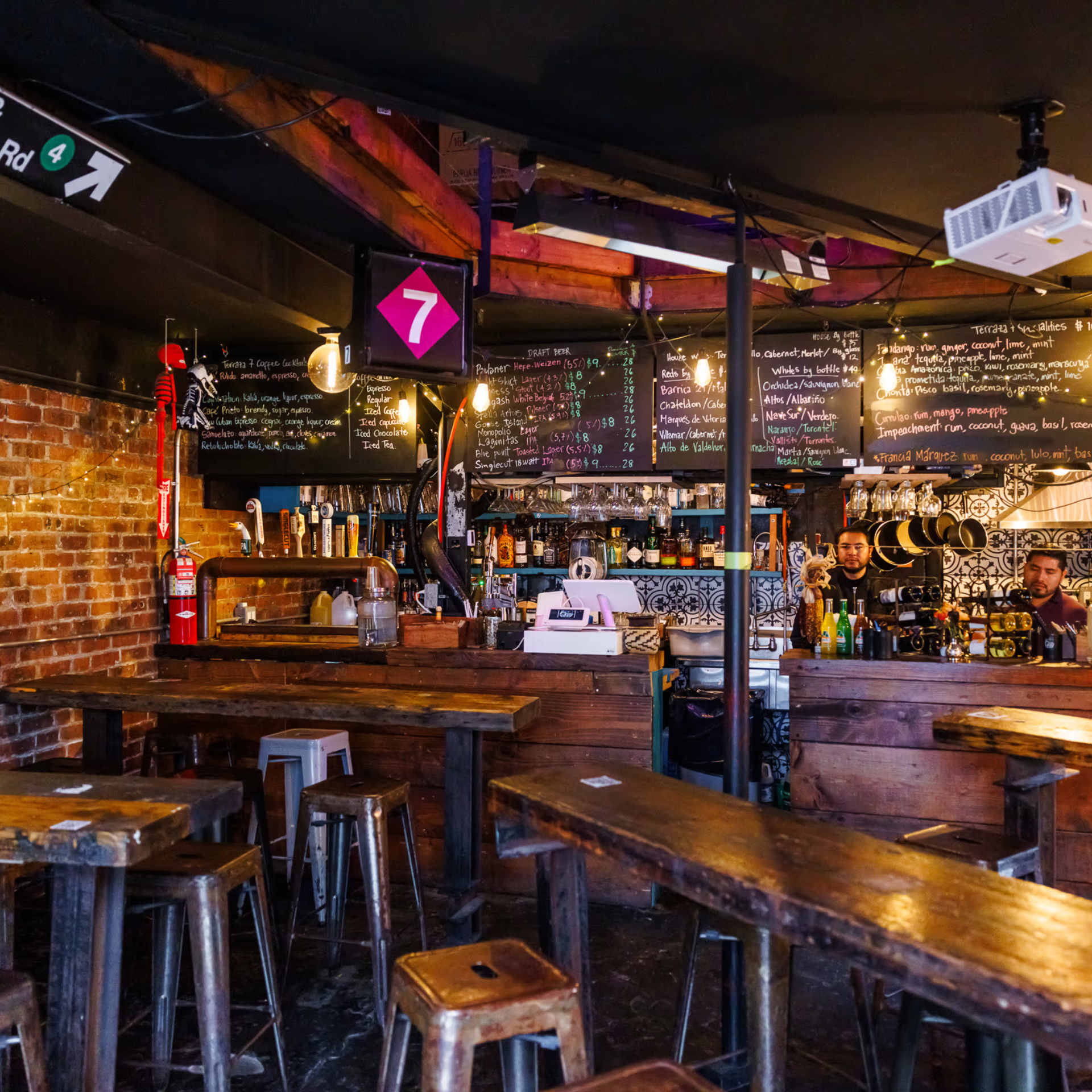 International Jazz Day NYC: Rustic pub interior with wooden tables, exposed brick walls, chalkboard menus, and warm hanging lights