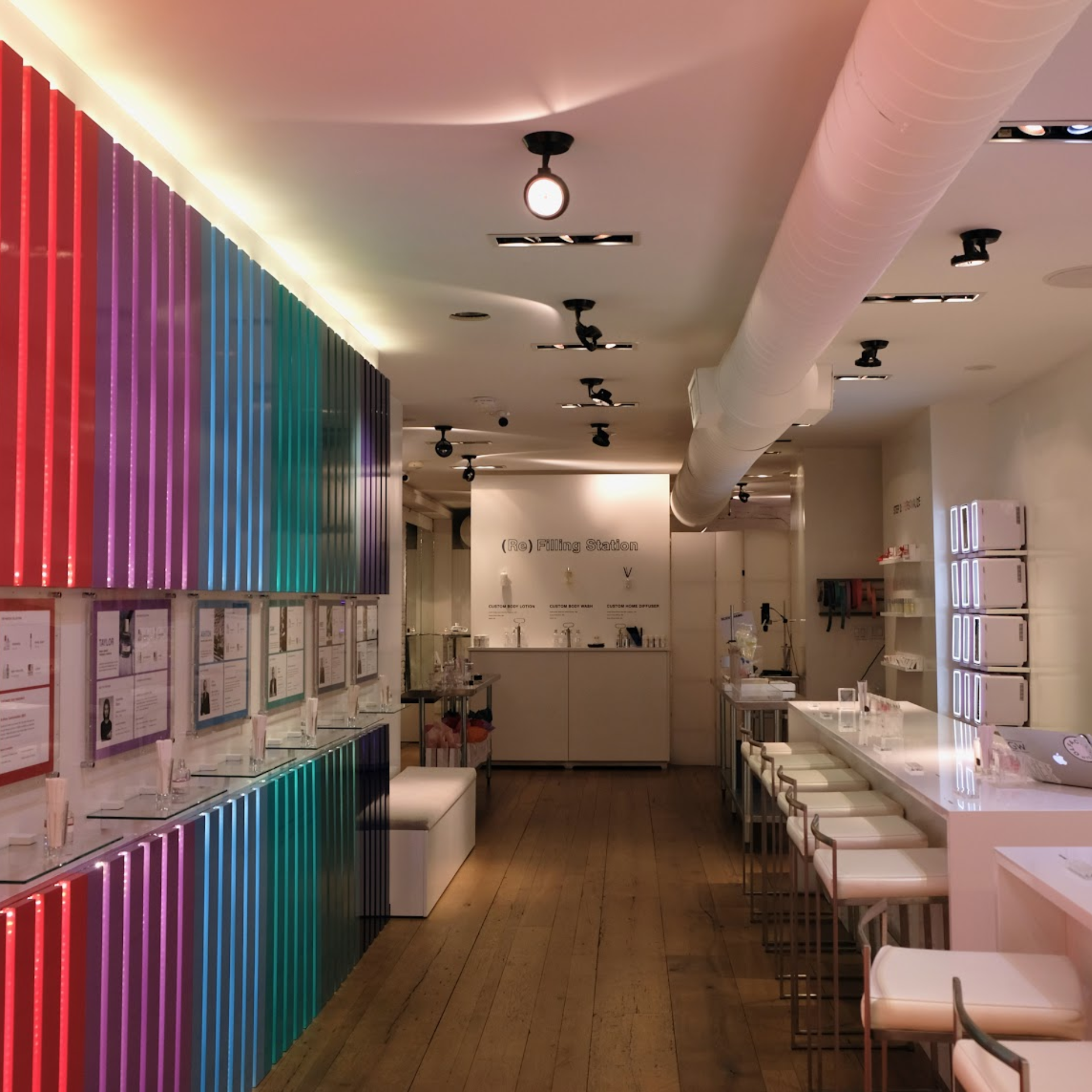 Bright modern store with colorful illuminated panels and refill station counter