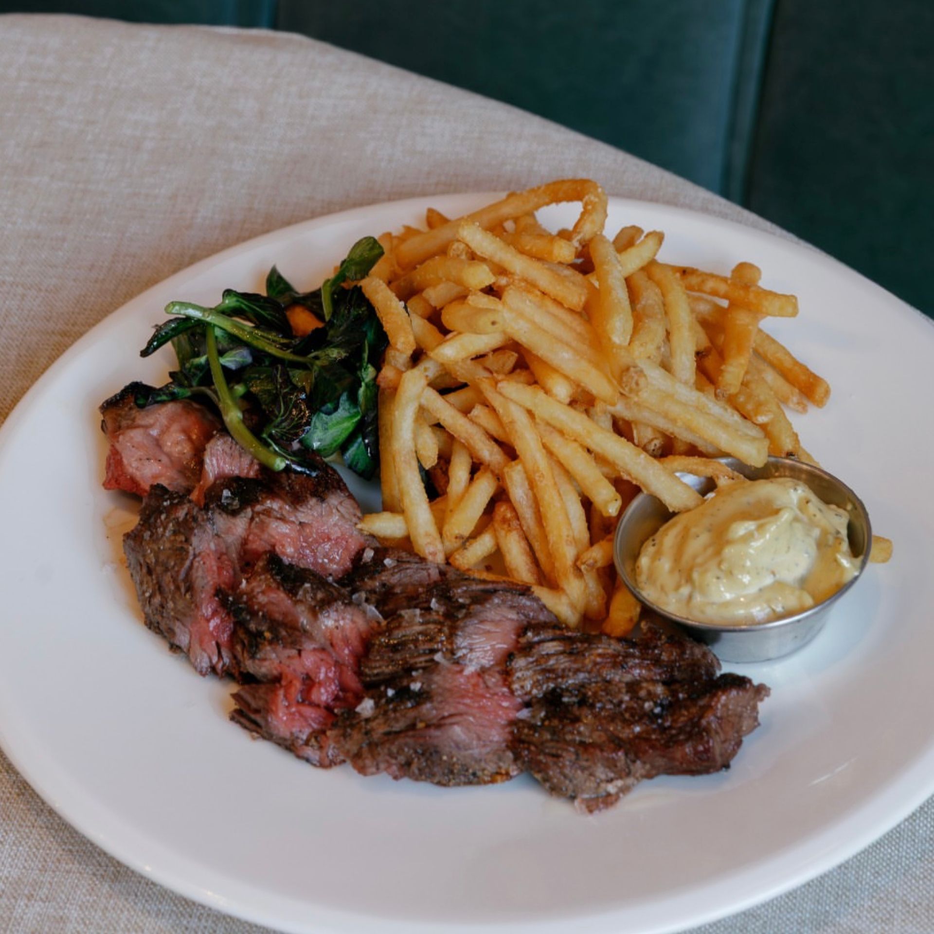 Grass-fed bavette steak with crispy potatoes, charred bitter greens, and balsamic mustard glaze at Sungold Arlo Williamsburg.