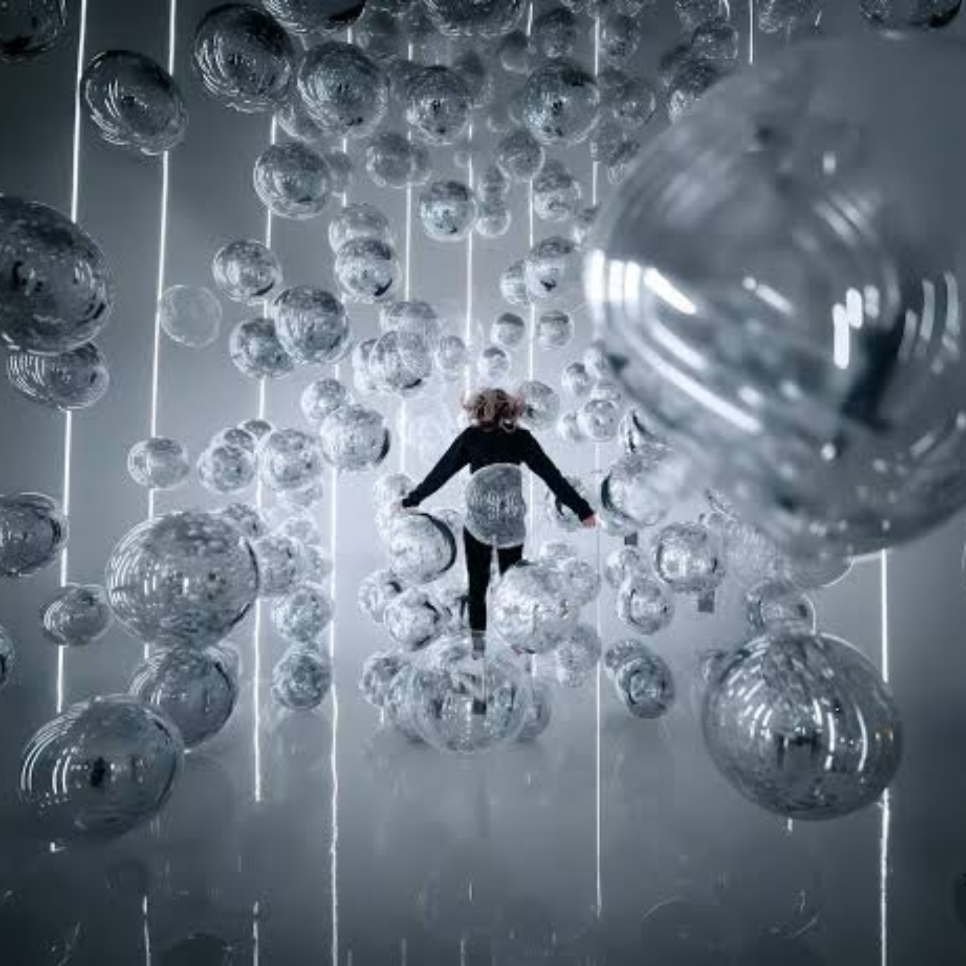 Immersive NYC art installation with reflective glass spheres suspended in futuristic room of light, surreal cultural experience featured in daily things to do in NYC any day