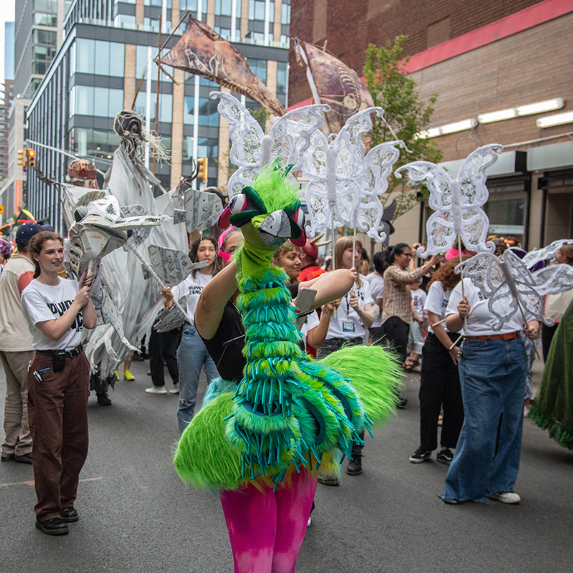 Colorful NYC street parade with feathered costume and butterfly decorations, festive cultural celebration featured in daily things to do in NYC any day