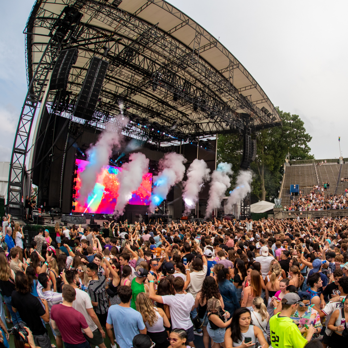 NYC Labor Day outdoor concert with stage, LED visuals, smoke jets, and dense cheering crowd, live music festival featured in daily things to do in NYC any day