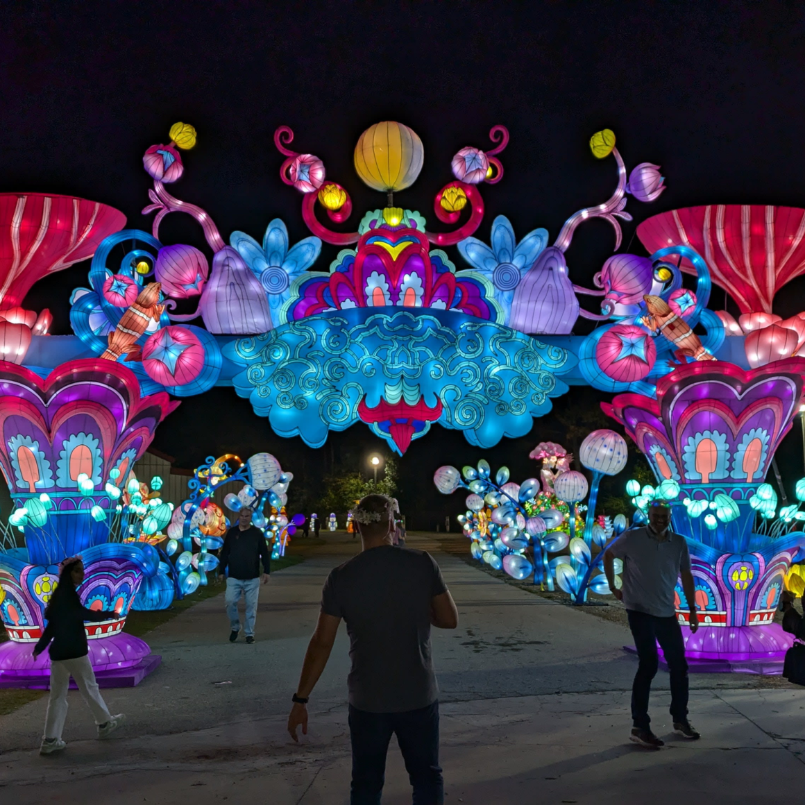 NYC Labor Day lantern festival at night with colorful illuminated archway and ornate light sculptures in blue, pink, purple, and yellow, festive cultural display featured in daily things to do in NYC any day