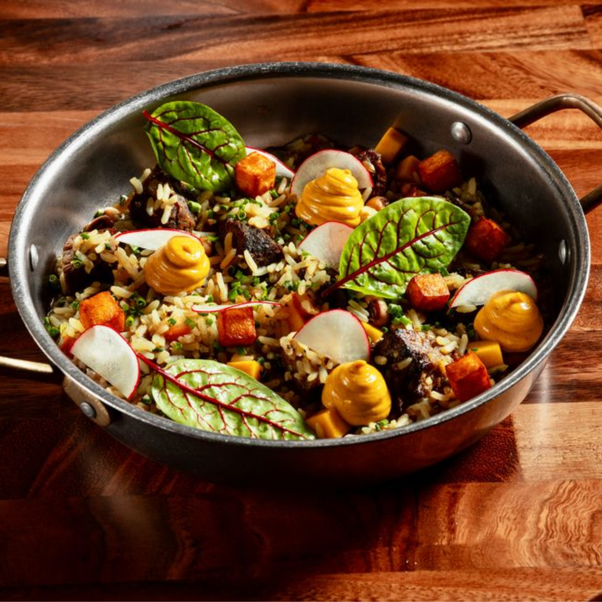 Pan of rice with roasted vegetables, mushrooms, radish, and greens
