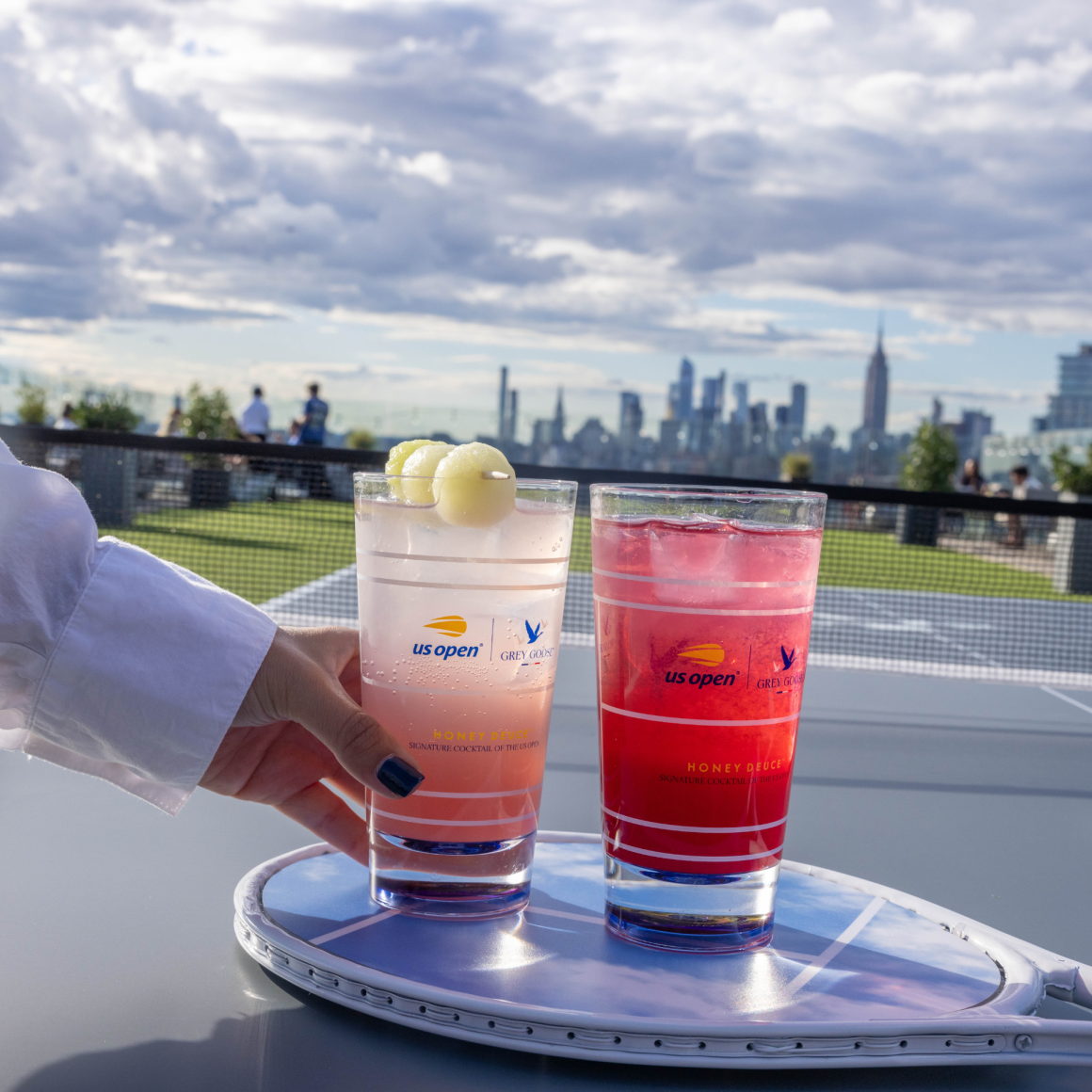 Two US Open cocktails on tennis racket with skyline view